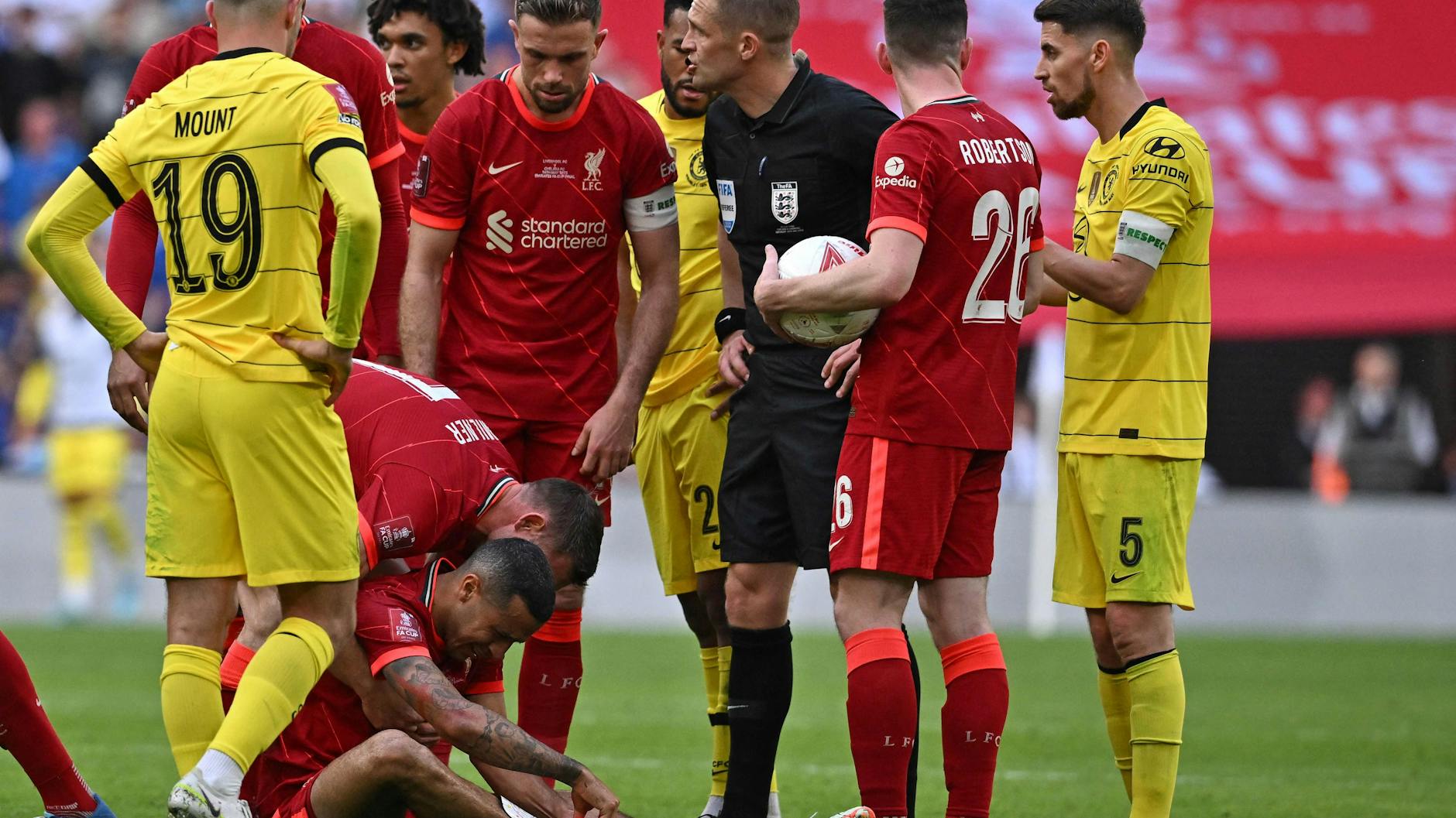Thiago, der Mittelfeldspieler vom FC Liverpool, sitzt nach einem Foul im Spiel gegen Chelsea angeschlagen am Boden.