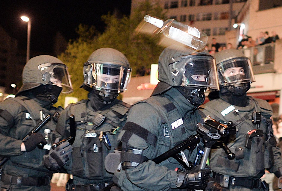 Polizisten werden auf einer 1.-Mai-Demo mit einer Flasche attackiert (Archivbild).