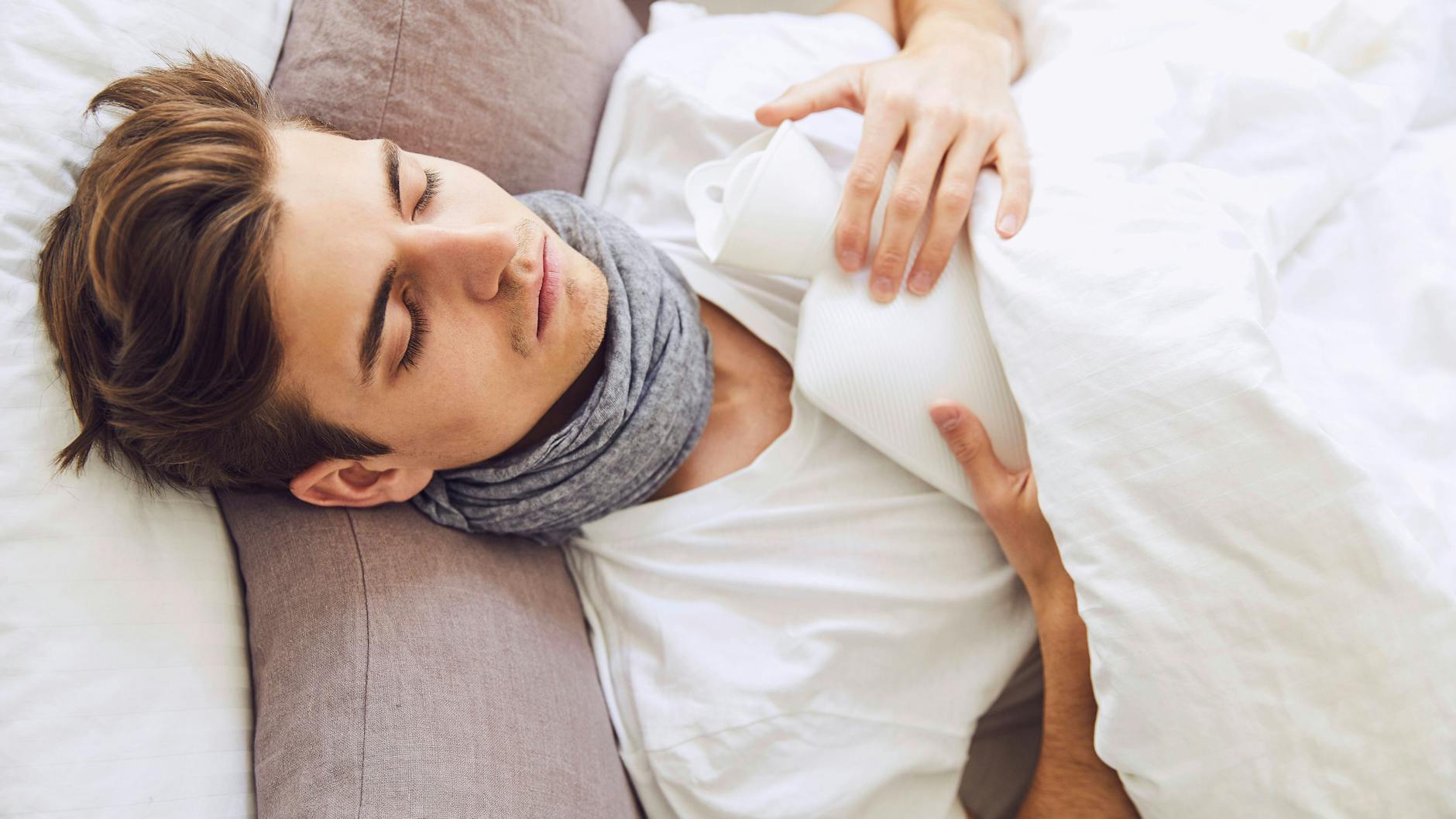 Ein kranker Mann liegt im Bett.