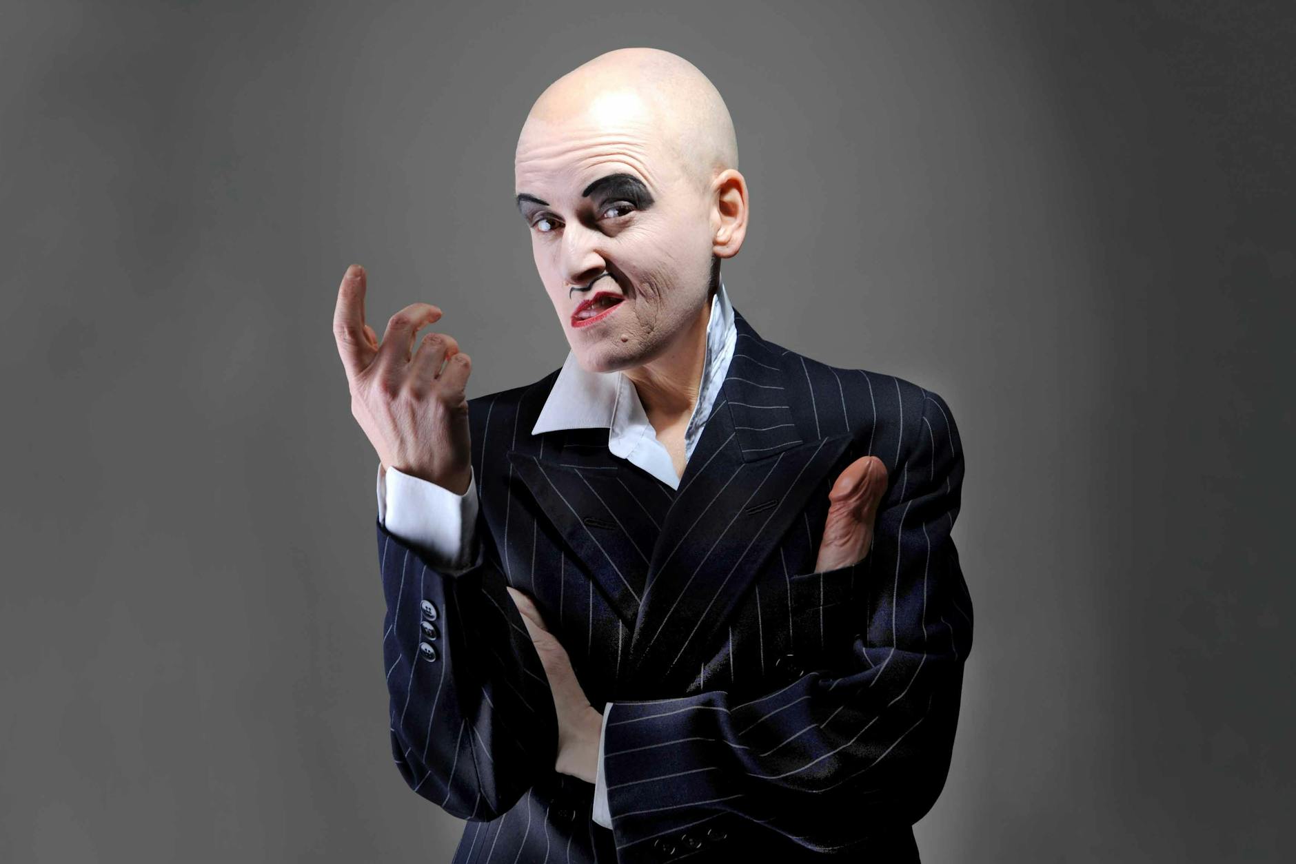 Bridge Markland auf der Bühne als Anzugträger „Steve“, einen Dildo in der Brusttasche