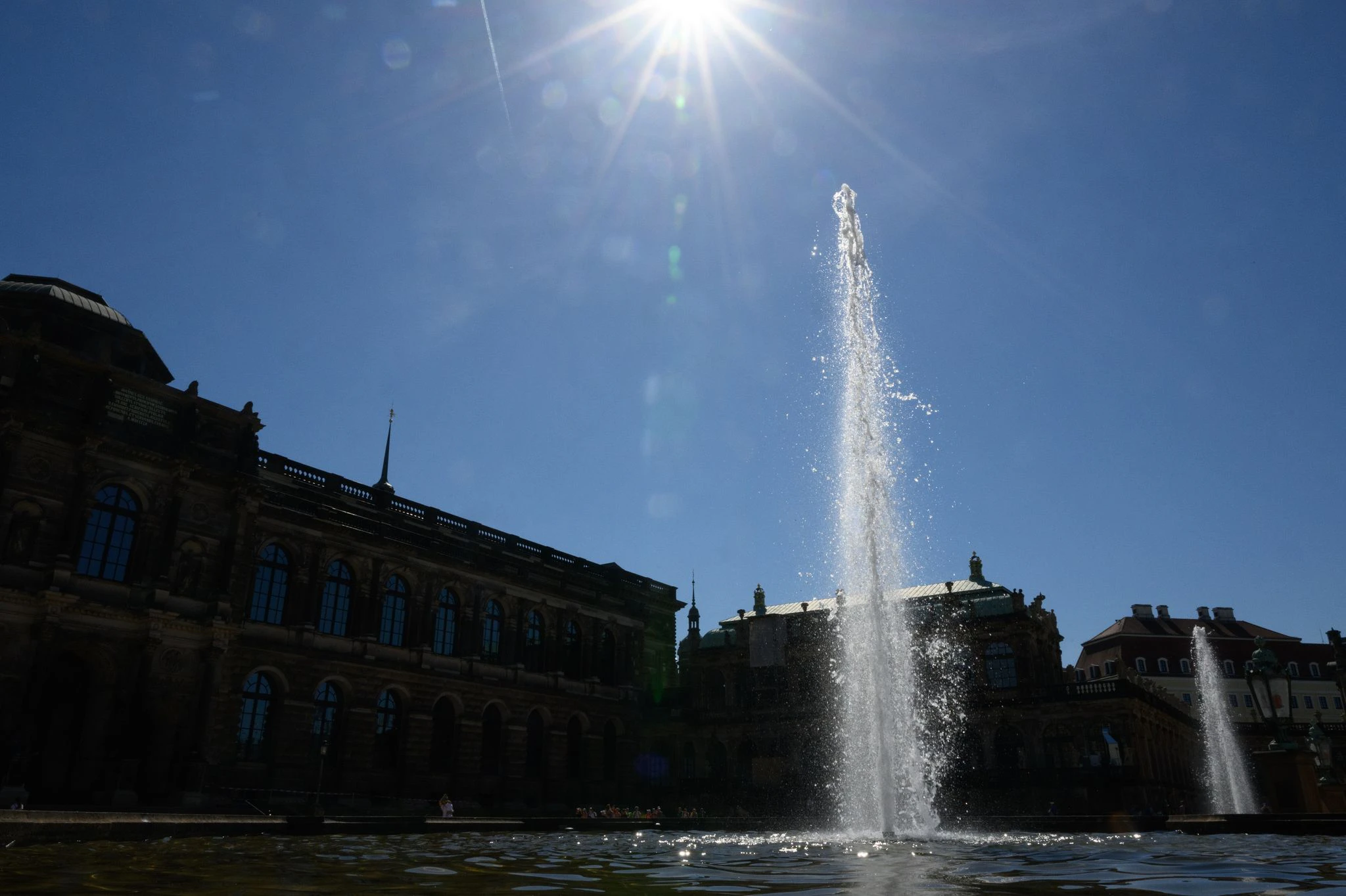 Im Dresdner Zwinger versprechen die Wasserfontänen eine Abkühlung, während die Sonne gnadenlos vom Himmel strahlt.  