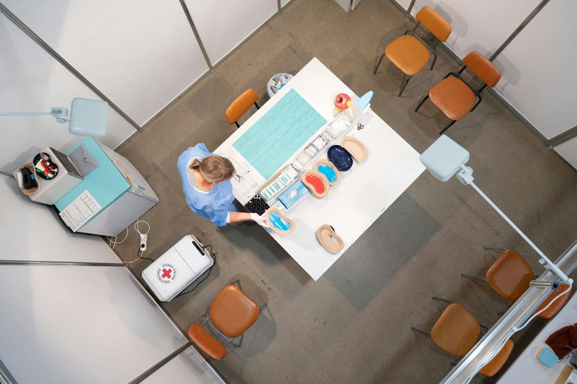 Eine Mitarbeiterin der Kassenärztlichen Vereinigung sortiert in einem Impfzentrum Corona-Vakzine.