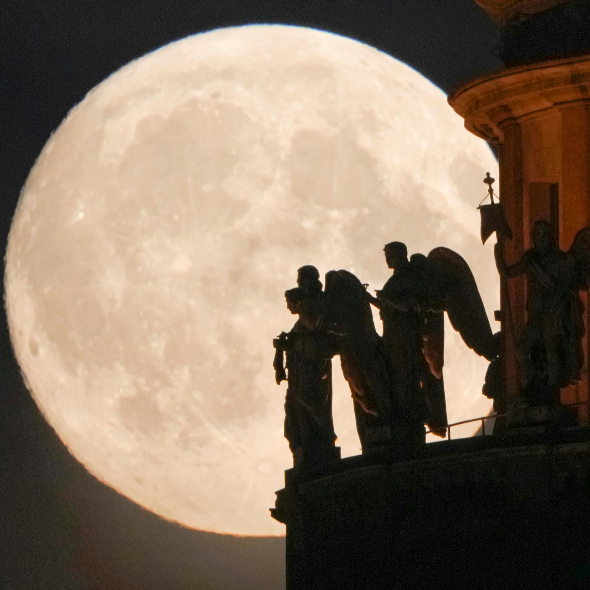 Engelsskulpturen an der Isaakskathedrale in St. Petersburg heben sich vom Vollmond ab.