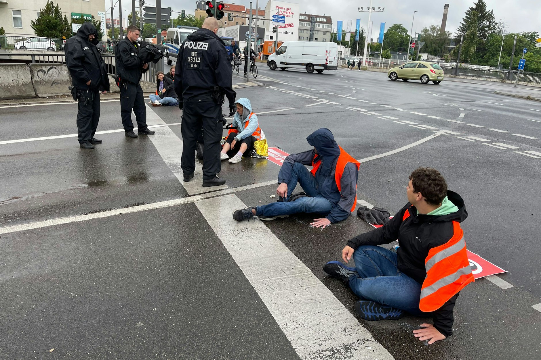Ein Grüppchen junger Leute hat sich an der Ausfahrt Spandauer Damm der A 100 mit den Händen auf dem Asphalt festgeklebt.
