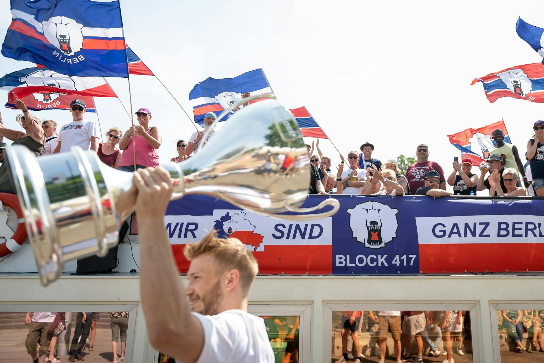 Ganz viel Stolz und ganz viel Vorfreude: Eisbären-Allrounder Eric Mik schreitet mit dem Meisterpokal die Schiffsfront ab, bevor er an Bord geht.