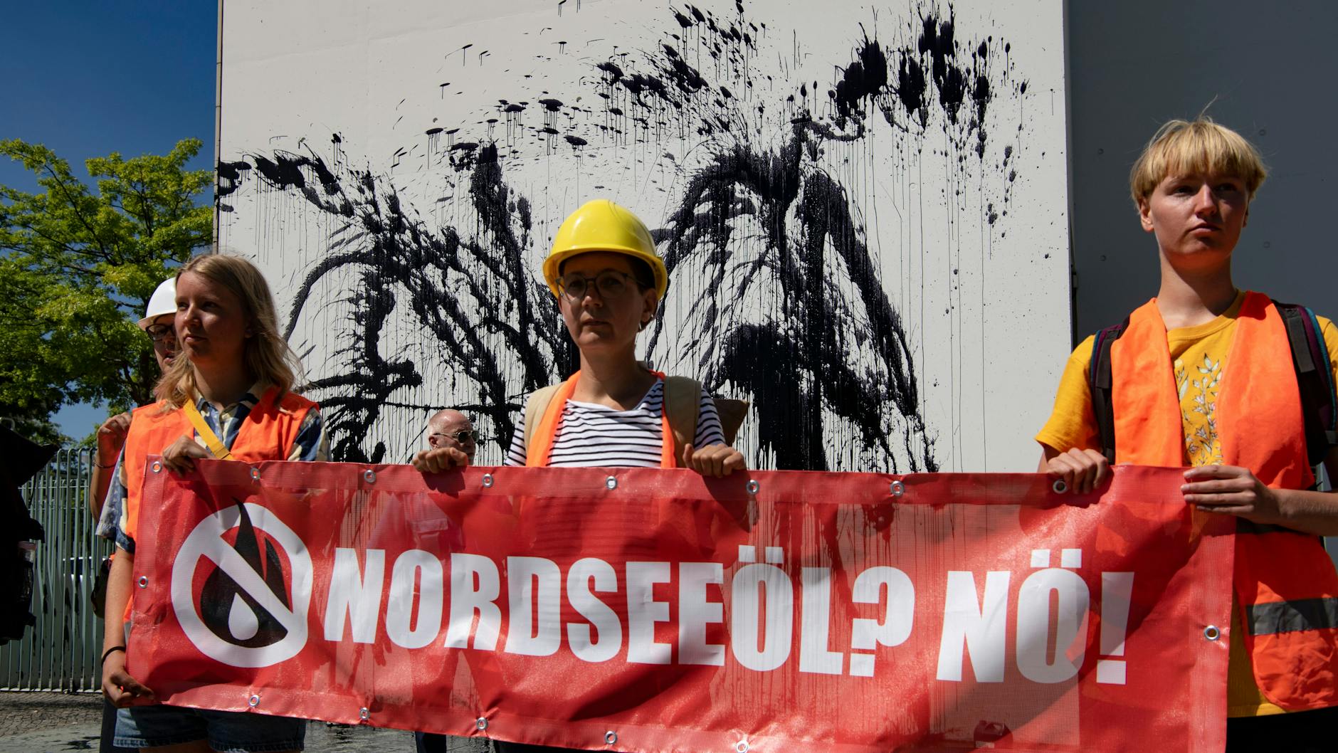 Die Letzte Generation vor einer beschmierten Wand am Kanzleramt