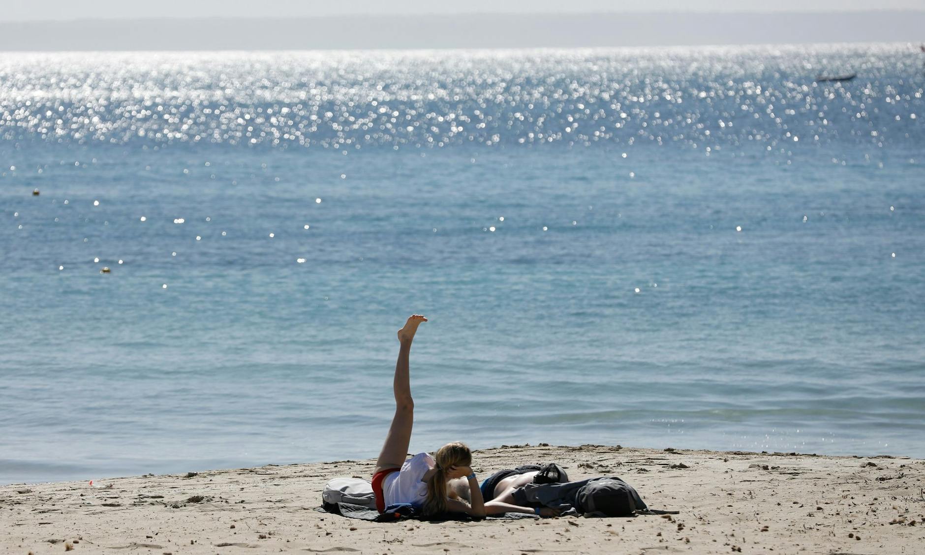 ARCHIV - Urlauber am Strand von Palmanova auf der Urlaubsinsel Mallorca: In Spanien gibt es kaum noch Corona-Beschränkungen.