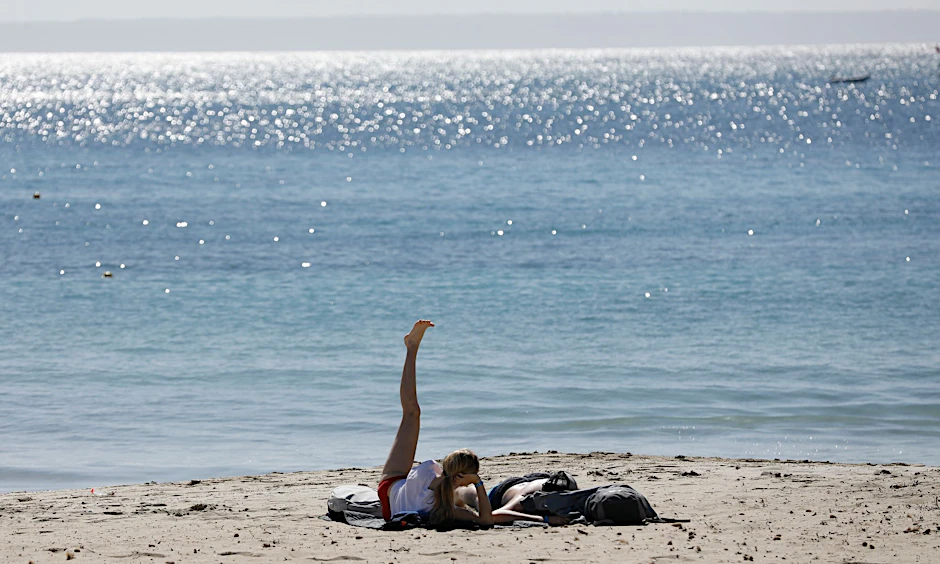 ARCHIV - Urlauber am Strand von Palmanova auf der Urlaubsinsel Mallorca: In Spanien gibt es kaum noch Corona-Beschränkungen.  