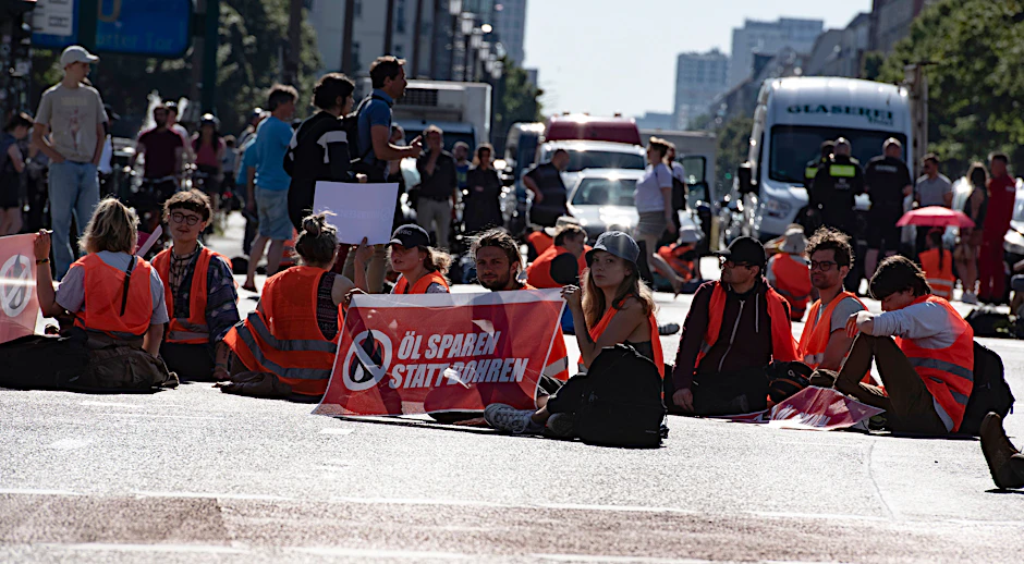 Klimaschutz-Demonstranten der Gruppe „Letzte Generation“ blockieren die Kreuzung am Frankfurter Tor. Zahlreiche Aktivisten klebten sich auf dem Asphalt fest.