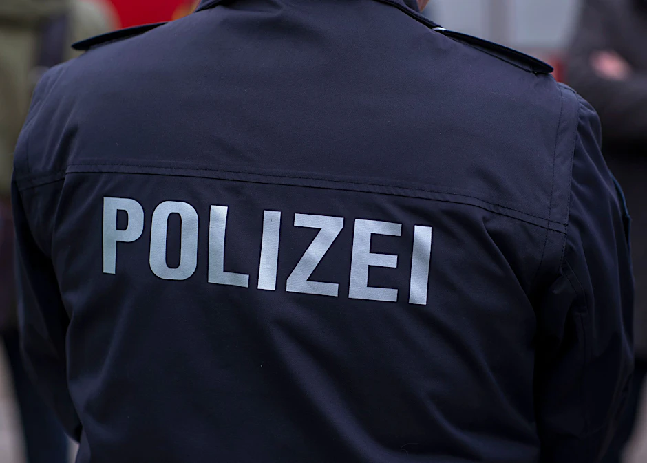 ARCHIV - «Polizei» steht auf der Uniform eines Polizisten.  