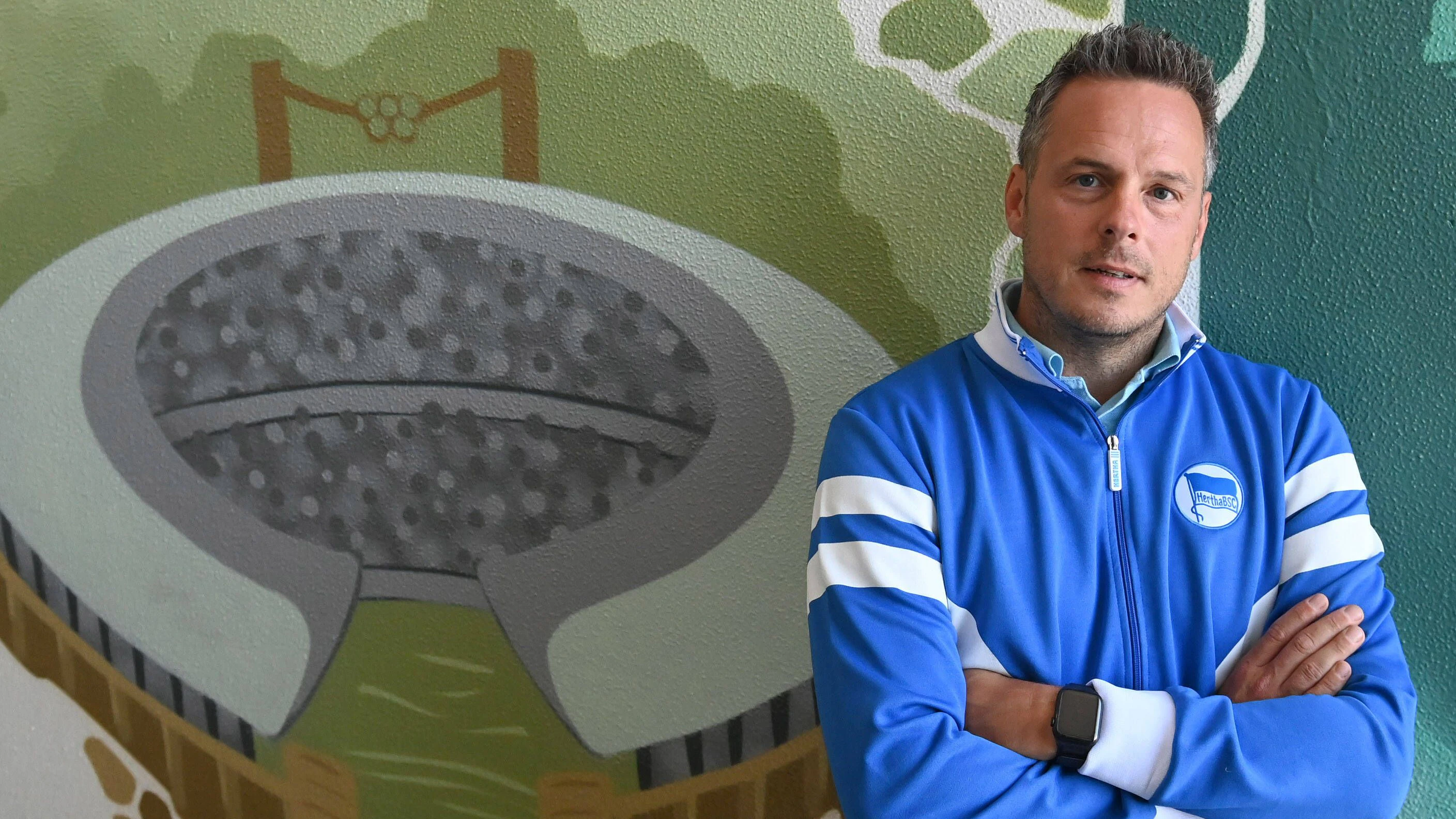 Herthas Präsidentschaftskandidat Kay Bernstein in seiner Firmenzentrale in Neukölln neben einem Graffiti des Berliner Olympiastadions.