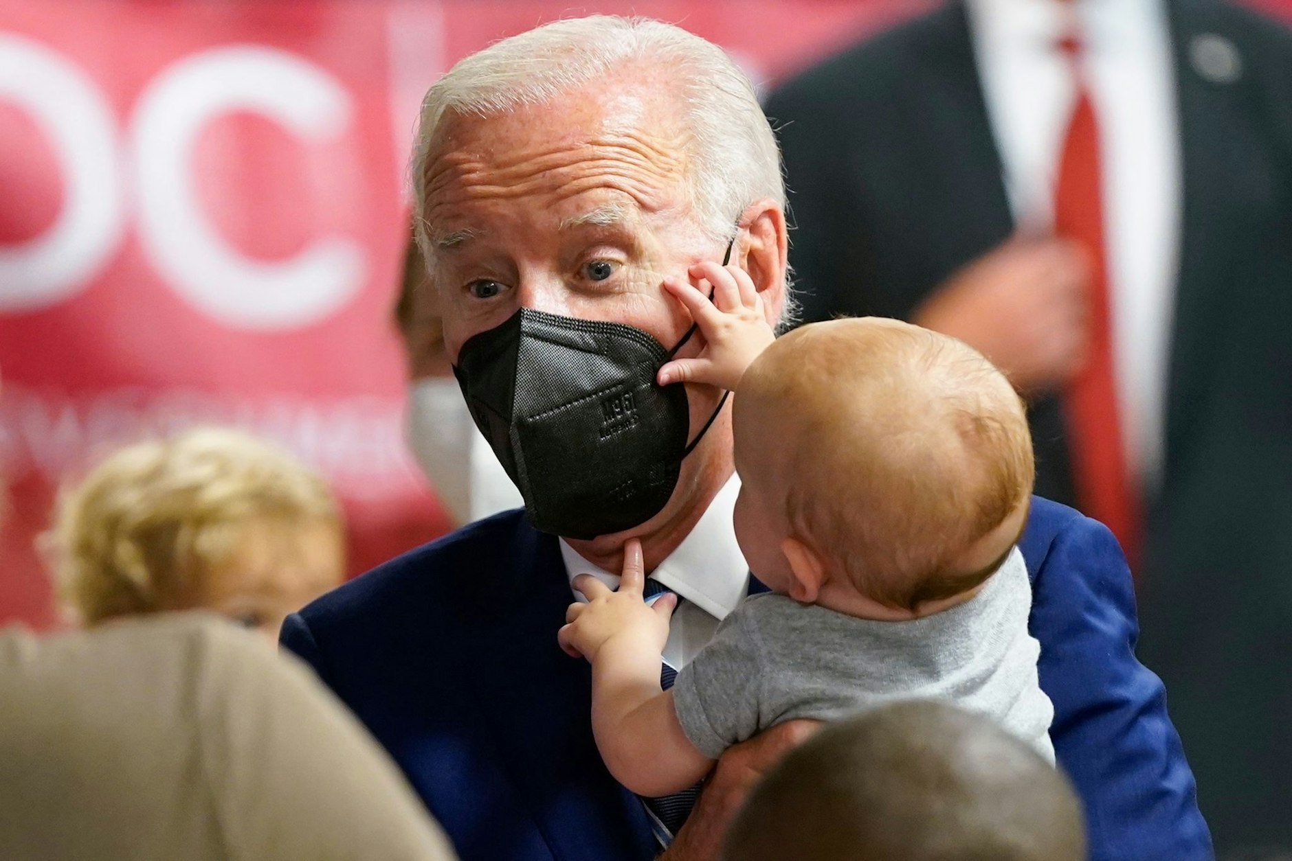 dpatopbilder - Ein Baby begutachtet US-Präsident Joe Biden in einer Corona-Impfklinik in Washington.  