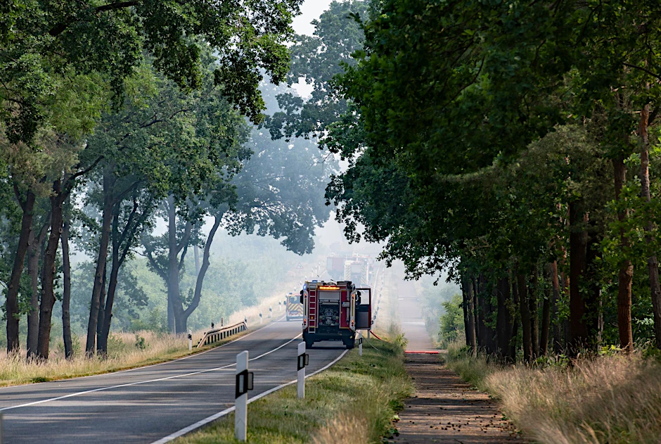 Einsatzfahrzeuge der Feuerwehr sind bei dem Waldbrand bei Treuenbrietzen im Einsatz.  