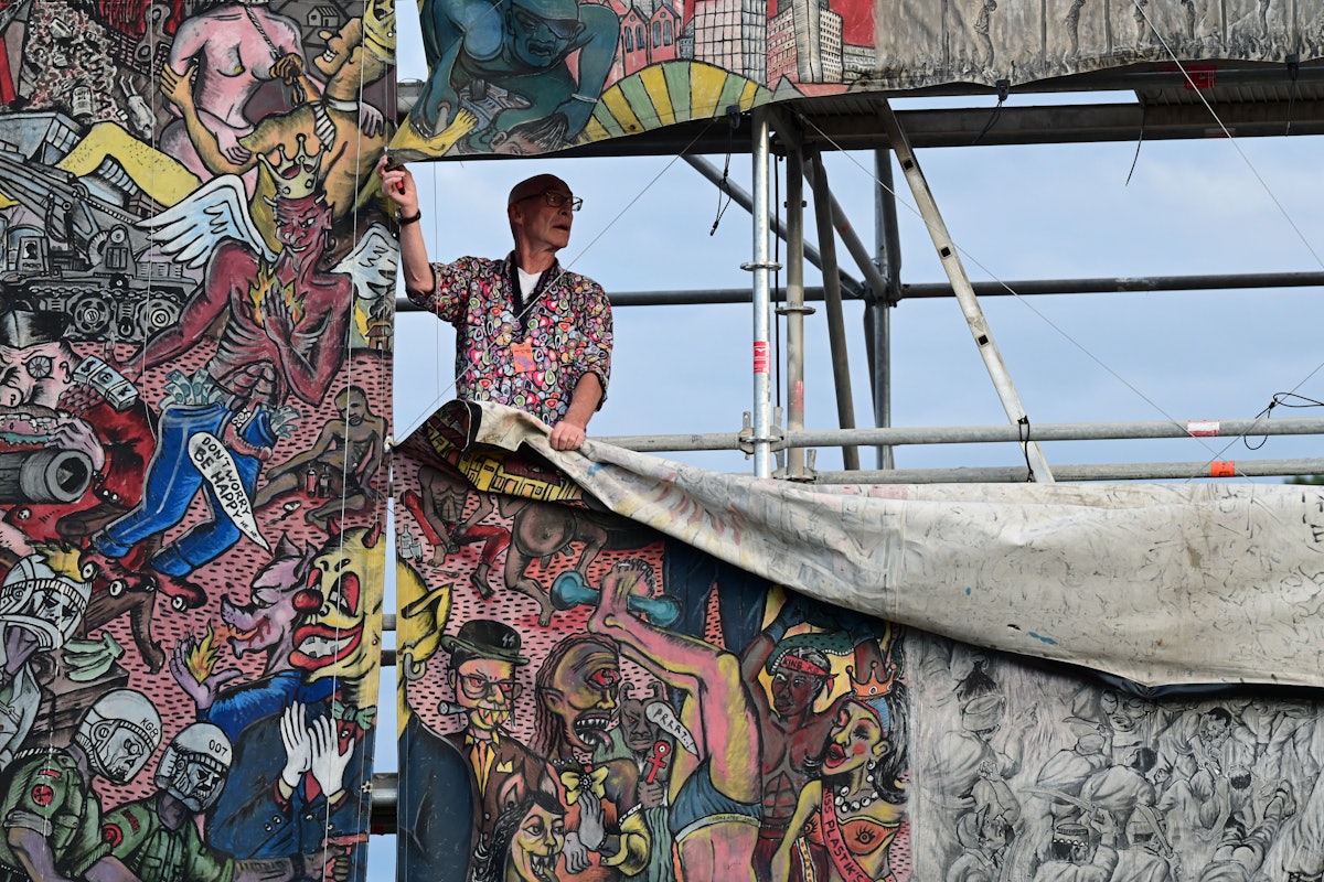 Seorang pekerja dokumen menghapus bagian dari spanduk besar yang kontroversial "keadilan rakyat" Oleh seniman kolektif Indonesia Taring Padi di Friedrichsplatz.