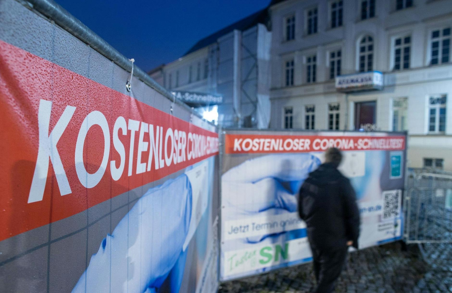 ARCHIV - Ein Passant geht an einem Corona-Testzentrum im Schweriner Stadtzentrum vorbei. a