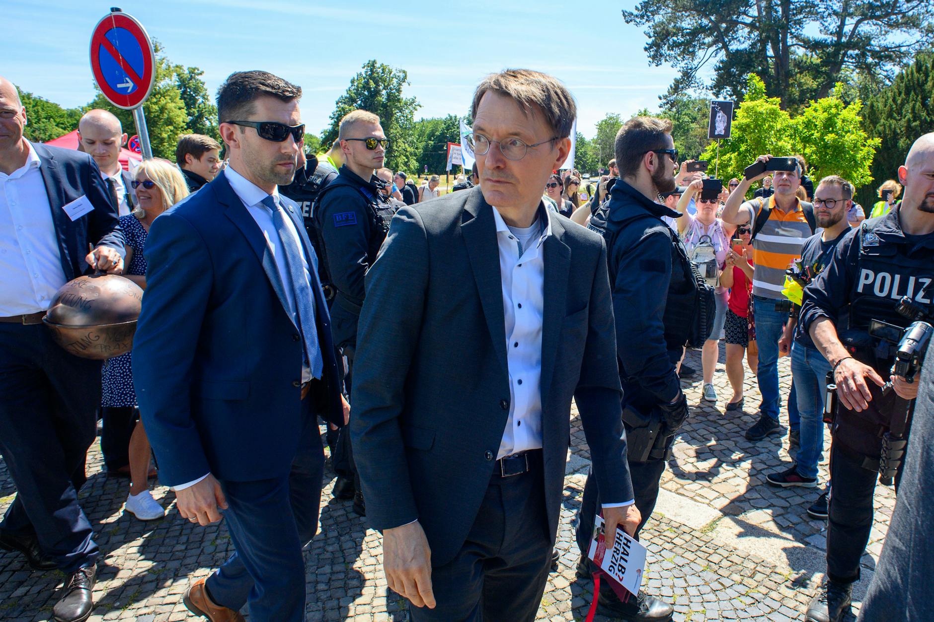 Bundesgesundheitsminister Karl Lauterbach (M, SPD) verlässt eine Kundgebung der Beschäftigten im Gesundheitswesen in Magdeburg. Dort hatte er sich mit ungeimpften Pflegekräften angelegt.