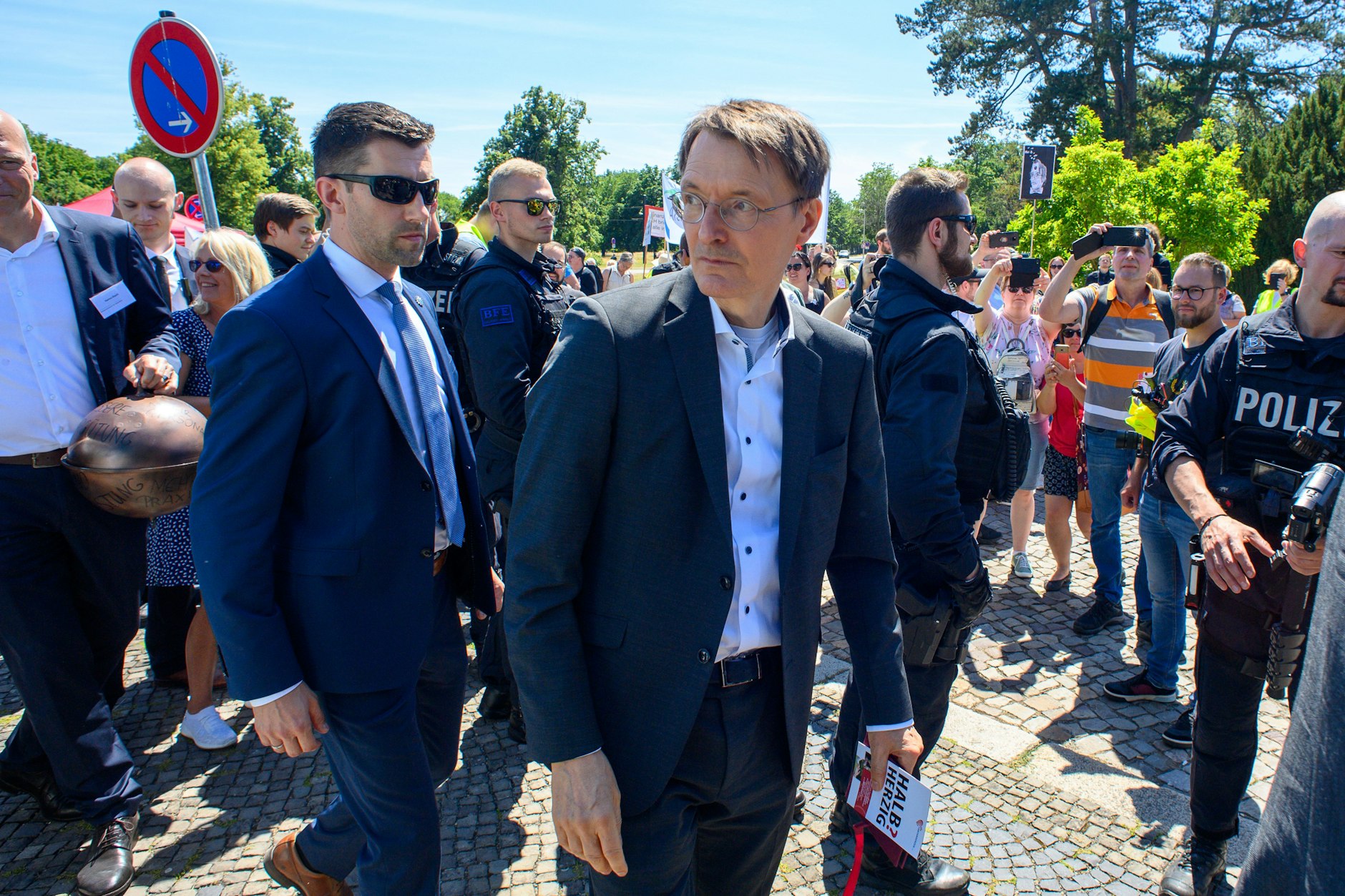 Bundesgesundheitsminister Karl Lauterbach (M, SPD) verlässt eine Kundgebung der Beschäftigten im Gesundheitswesen in Magdeburg. Dort hatte er sich mit ungeimpften Pflegekräften angelegt.