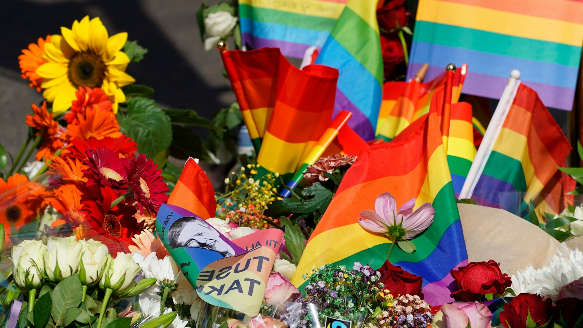 Menschen haben Blumen und LGBT-Flaggen vor dem Nachtclub „London Pub“ im Zentrum von Oslo niedergelegt, nachdem in der vergangenen Nacht um 1.15 Uhr dort mehrere Schüsse gefallen waren, bei denen zwei Menschen getötet und mehrere verletzt wurden