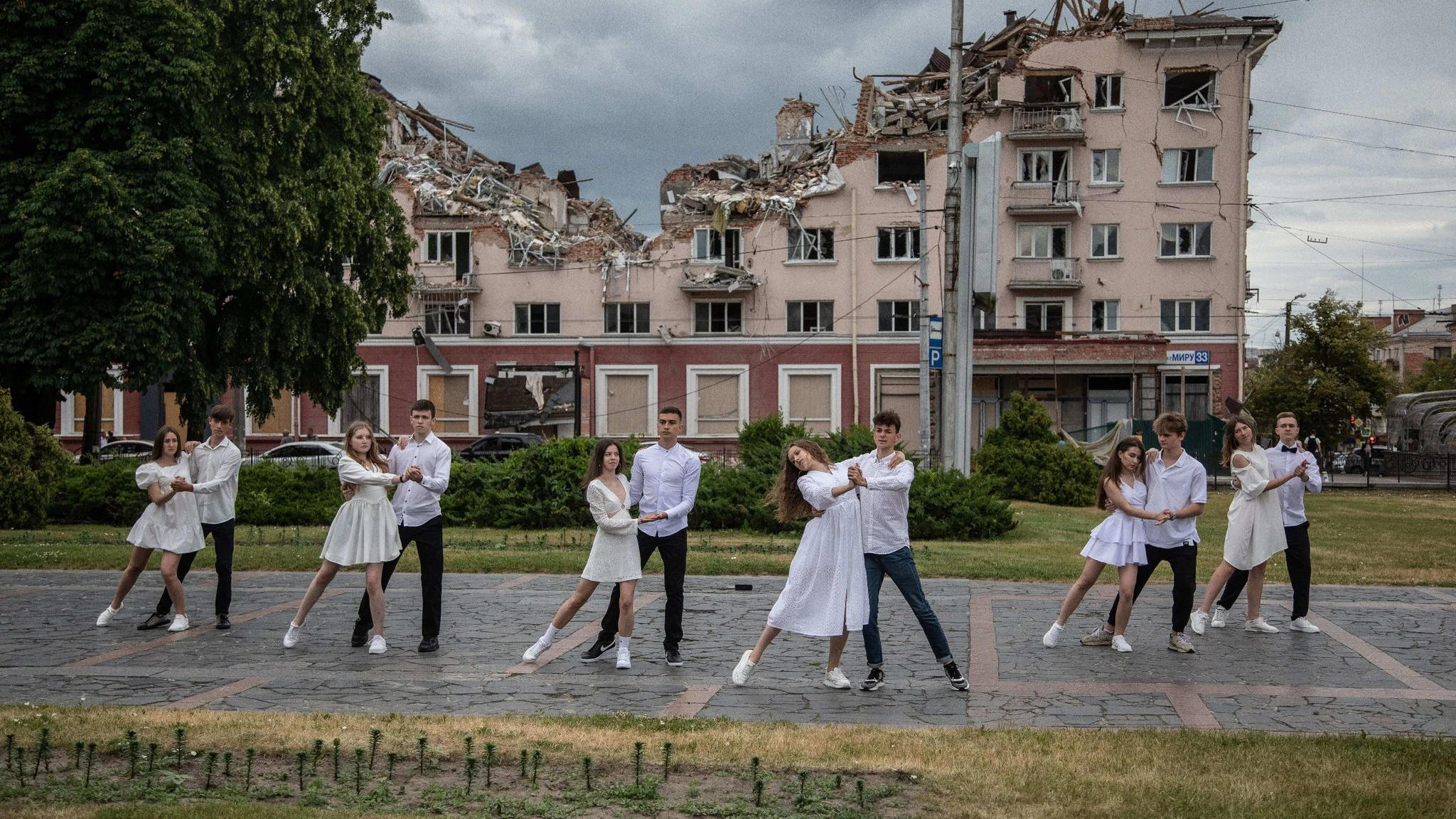 Fast surreal wirkt diese Aufnahme von Abiturienten einer Schule aus Tschernihiw, die vor einem zerstörten Hotel tanzen.  