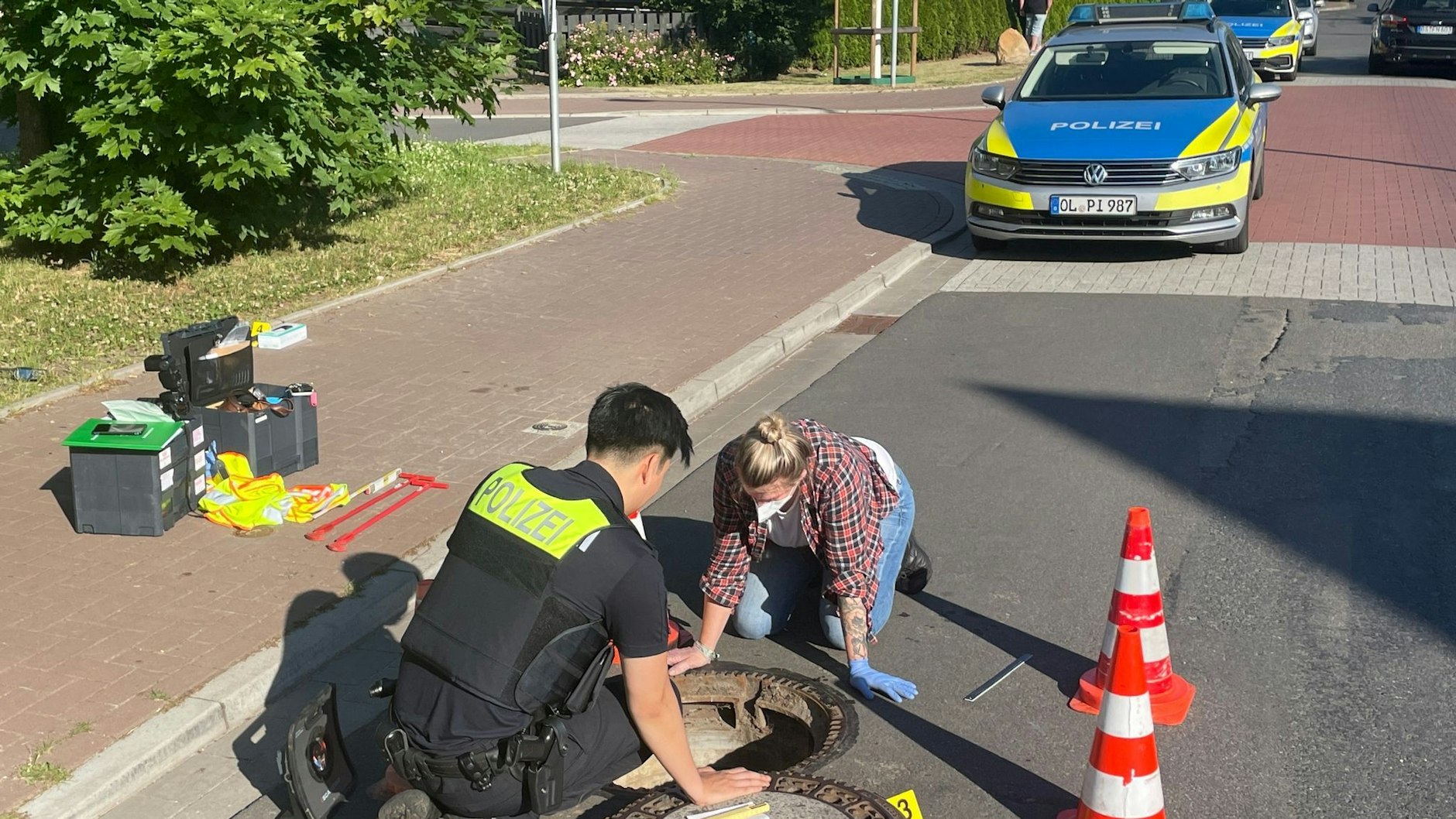 Polizisten inspizieren einen Gully - der Junge wurde hier nach mehr als einer Woche wiedergefunden.