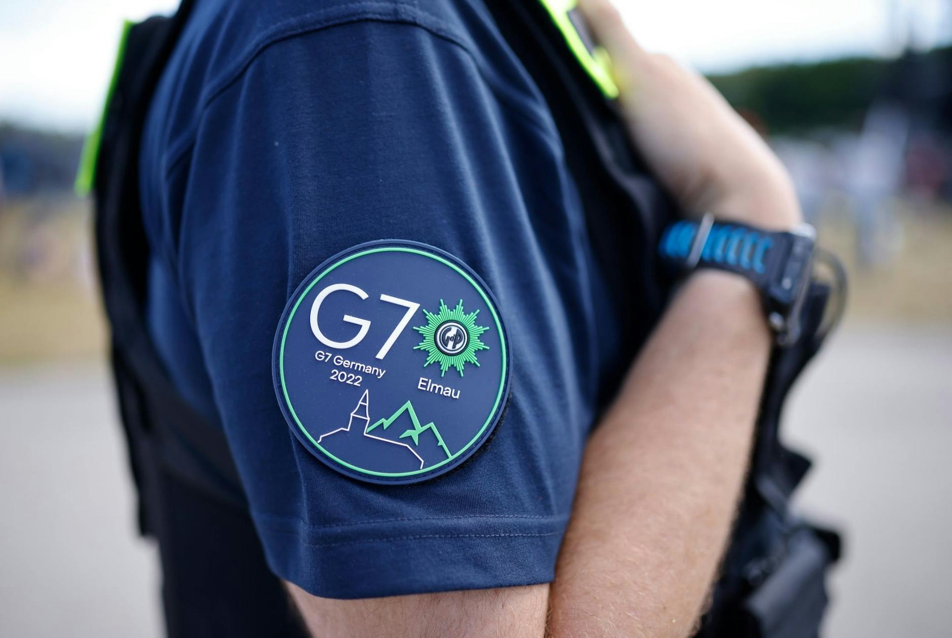 Das G7-Logo ist auf dem Ärmel eines Polizisten zu sehen.