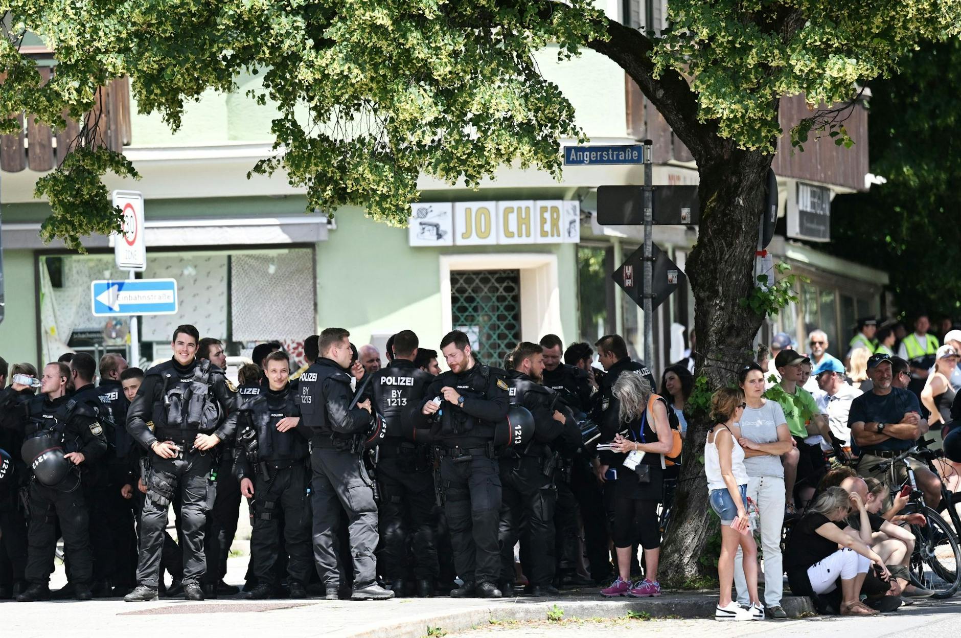 Polizisten suchen bei der Kundgebung vor der Demonstration des Bündnisses «Stop G7 Elmau» Schatten unter einem Baum.
