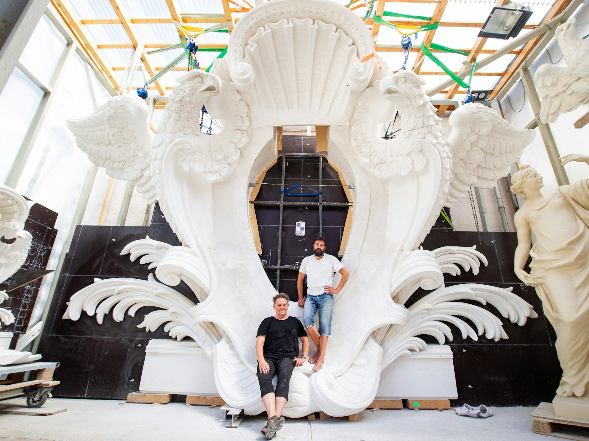 Das Gipsmodell für die Große Schlosskartusche in der Werkstatt von Steinbildhauer Andreas Hoferick (l.). Gemeinsam mit Oleg Bessonov hat er die Vorlage für die finale Ausführung als Kupfertreibarbeit geschaffen. Ins Zentrum wird der Wappenspiegel eingefügt.