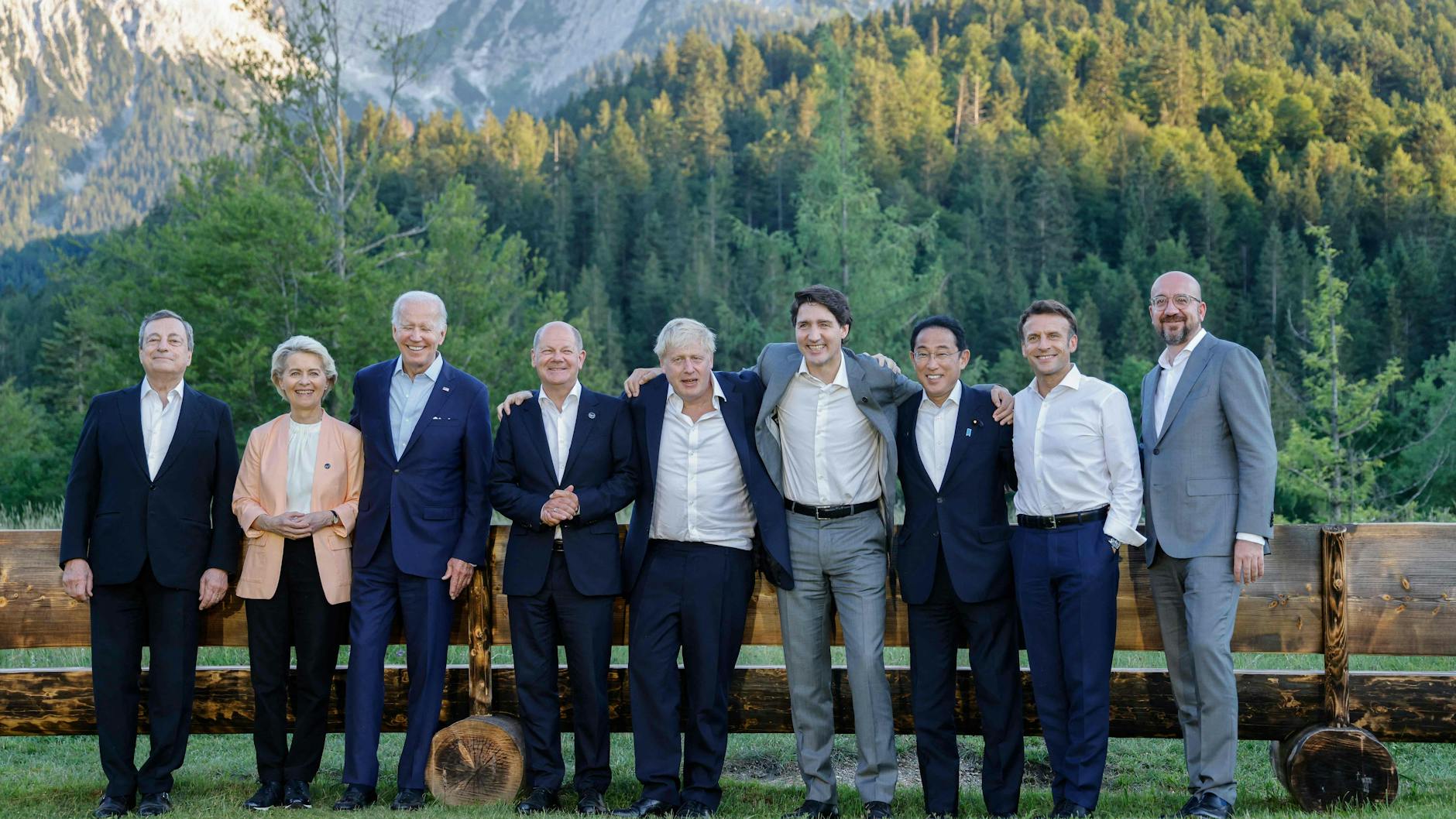 Weltenlenker posieren vor Alpenpanorama.