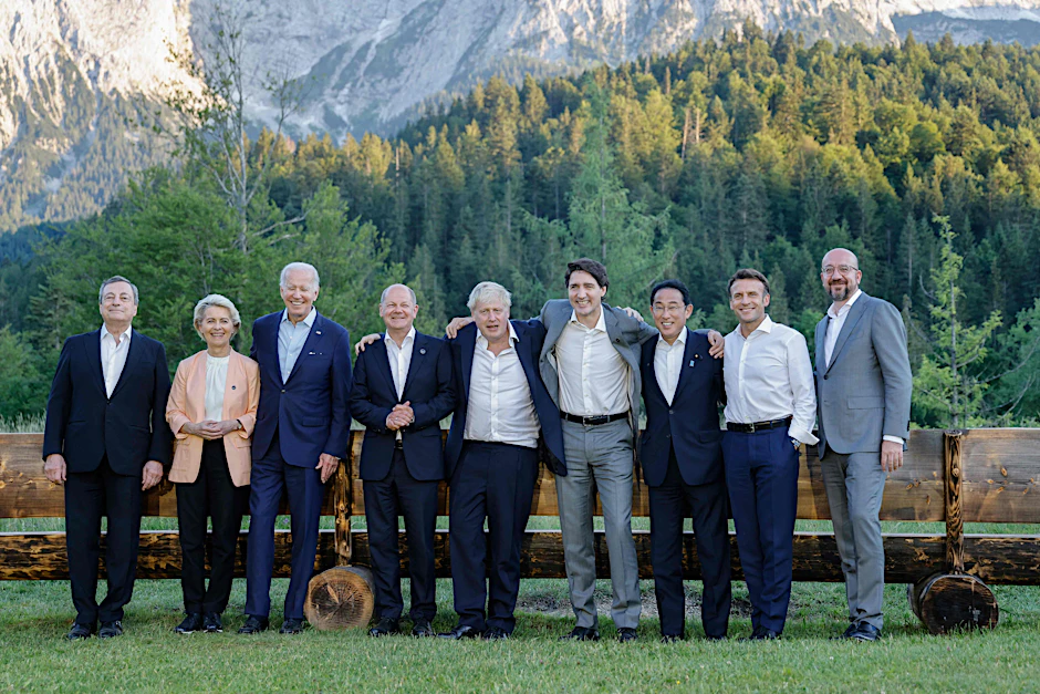 Weltenlenker posieren vor Alpenpanorama.