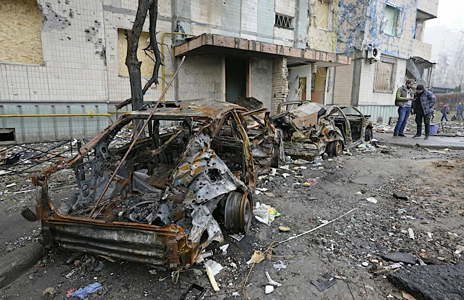 Ausgebrannte Fahrzeuge stehen nach einem russischen Raketenangriff vor einem Gebäude in der Ukraine (Symbolbild).