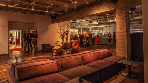 „Panorama Loft“ mit edlem dunkelbraunen Parkett und verschiedene Loungemöbel.