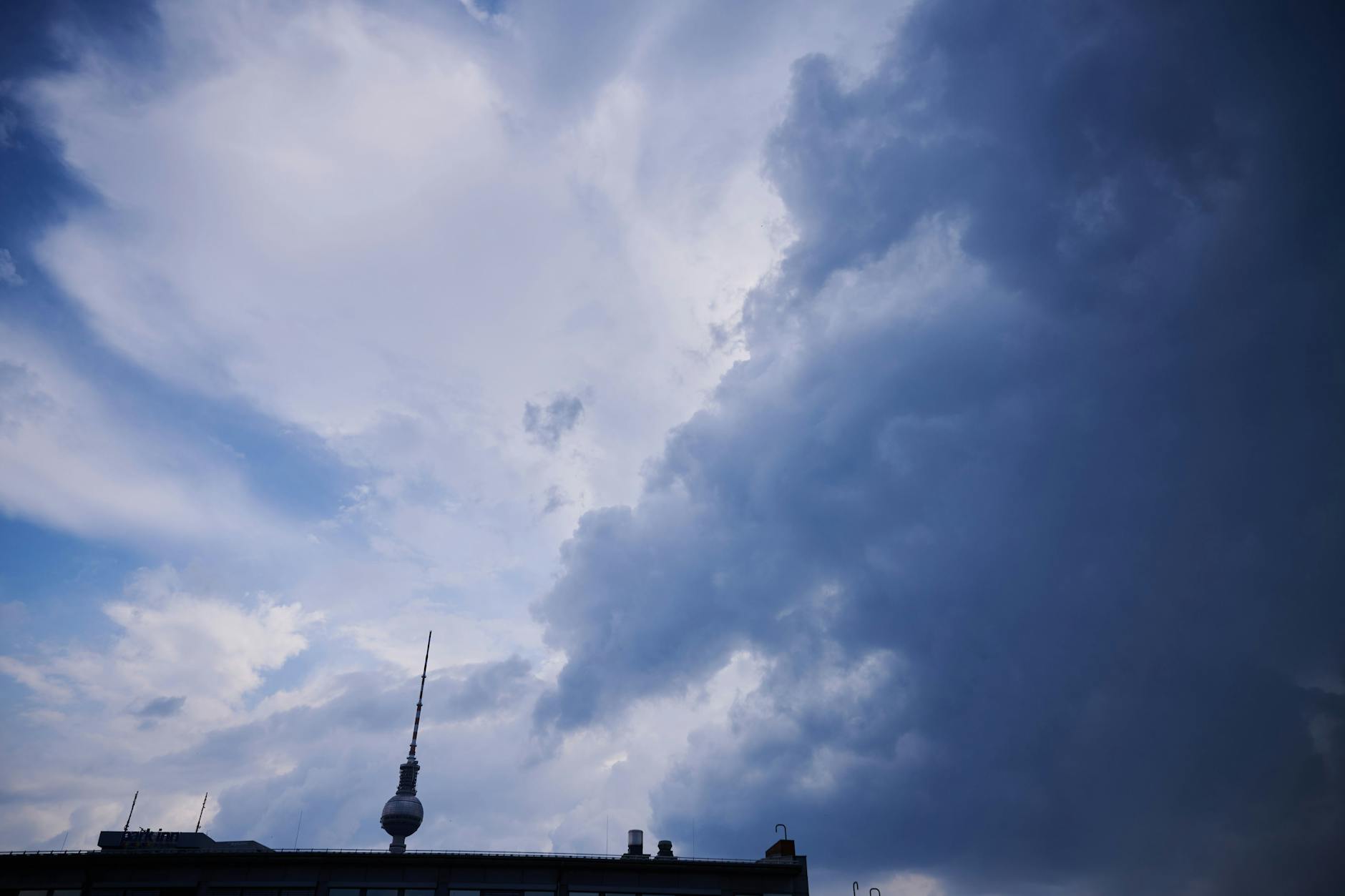 Dunkle Wolken ziehen in Richtung des Fernsehturms. Am Wochenende herrscht schwüle Hitze in Berlin, meinen die Wetter-Experten.