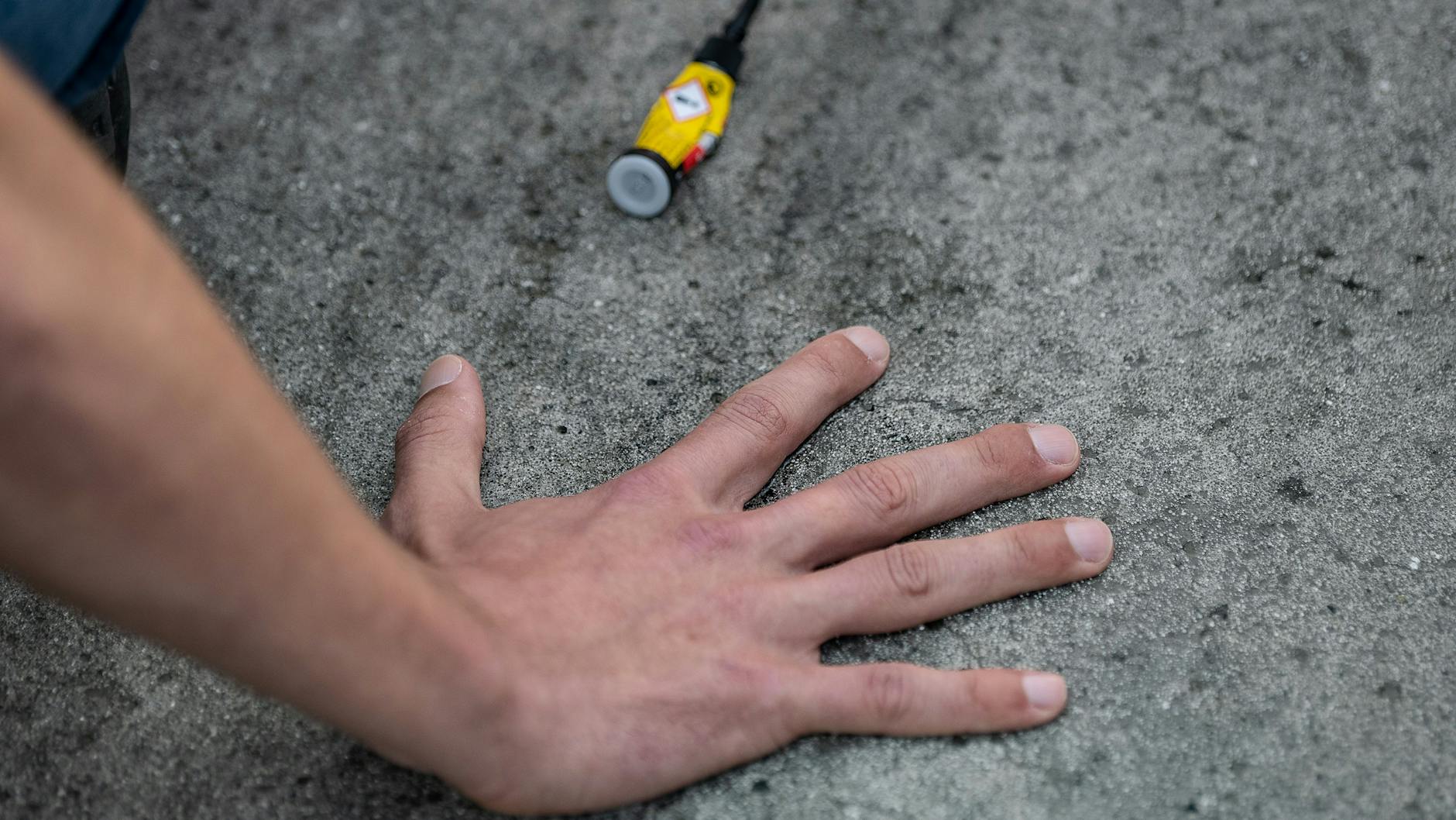 Ein Aktivist der Gruppe "Letzte Generation", der seine Hand selbst auf der Straße festgeklebt hat. (Archivbild)