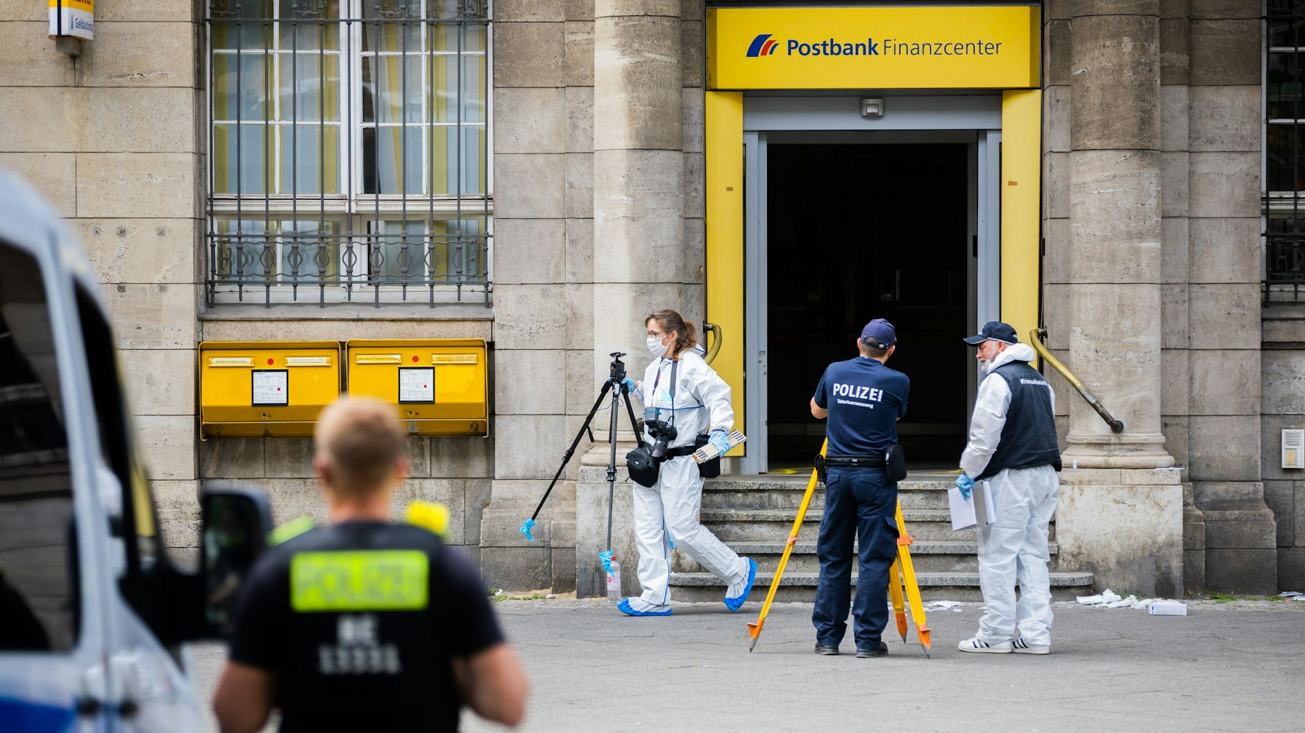 Polizisten bei der Spurensicherung vor der Postbankfiliale in der Uhlandstraße.