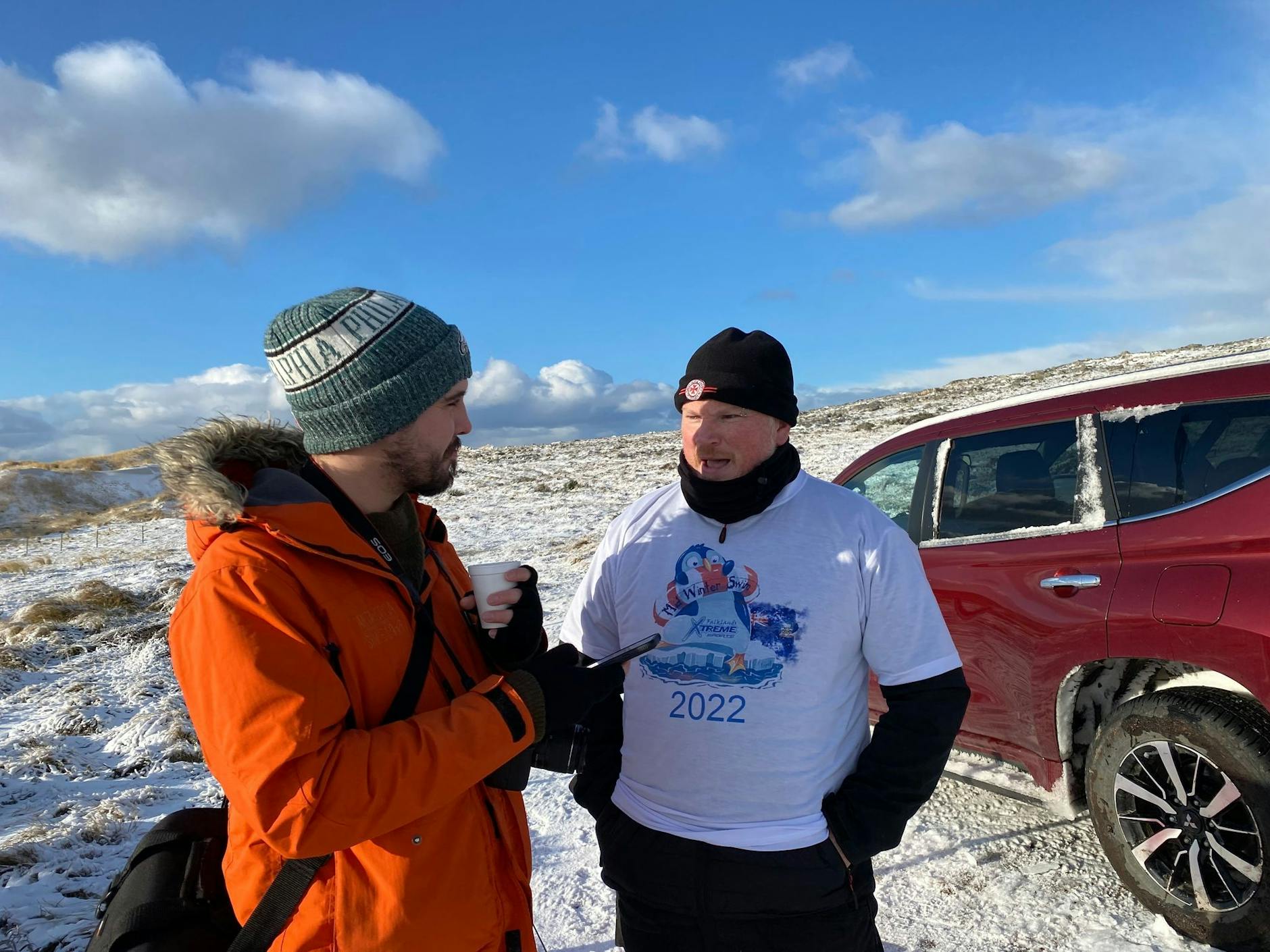 PRODUKTION - «Penguin News»-Reporter Nick Roberts (l) im Interview mit Marcus Morrison, Organisator des Winterschwimmens auf den Falklandinseln.