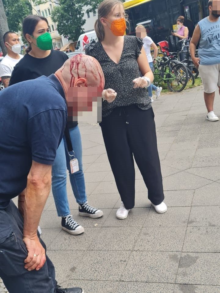 Das Bild zeigt den blutenden Geldtransporteur, der von Ersthelferinnen versorgt wird.