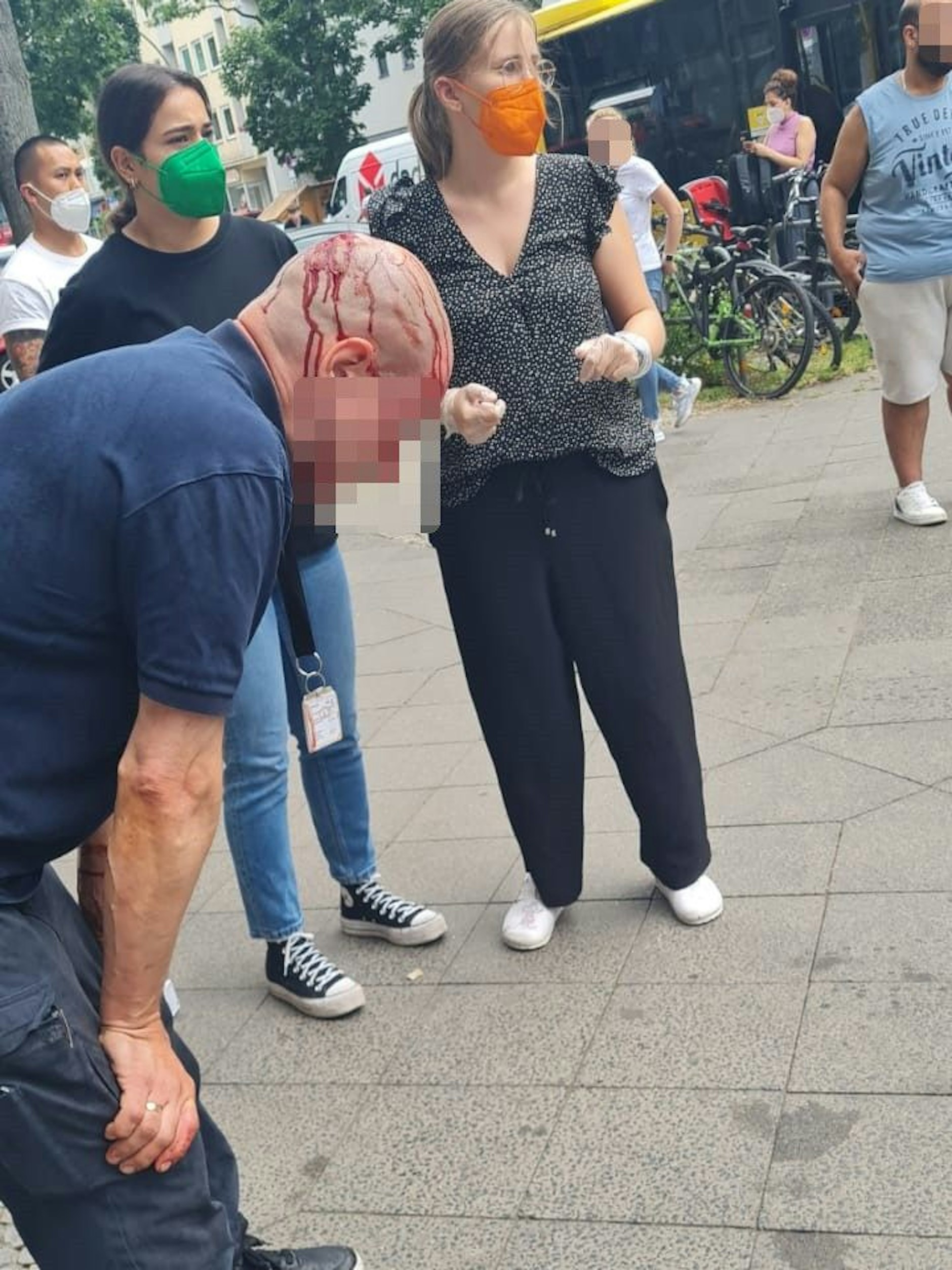 Das Bild zeigt den blutenden Geldtransporteur, der von Ersthelferinnen versorgt wird.