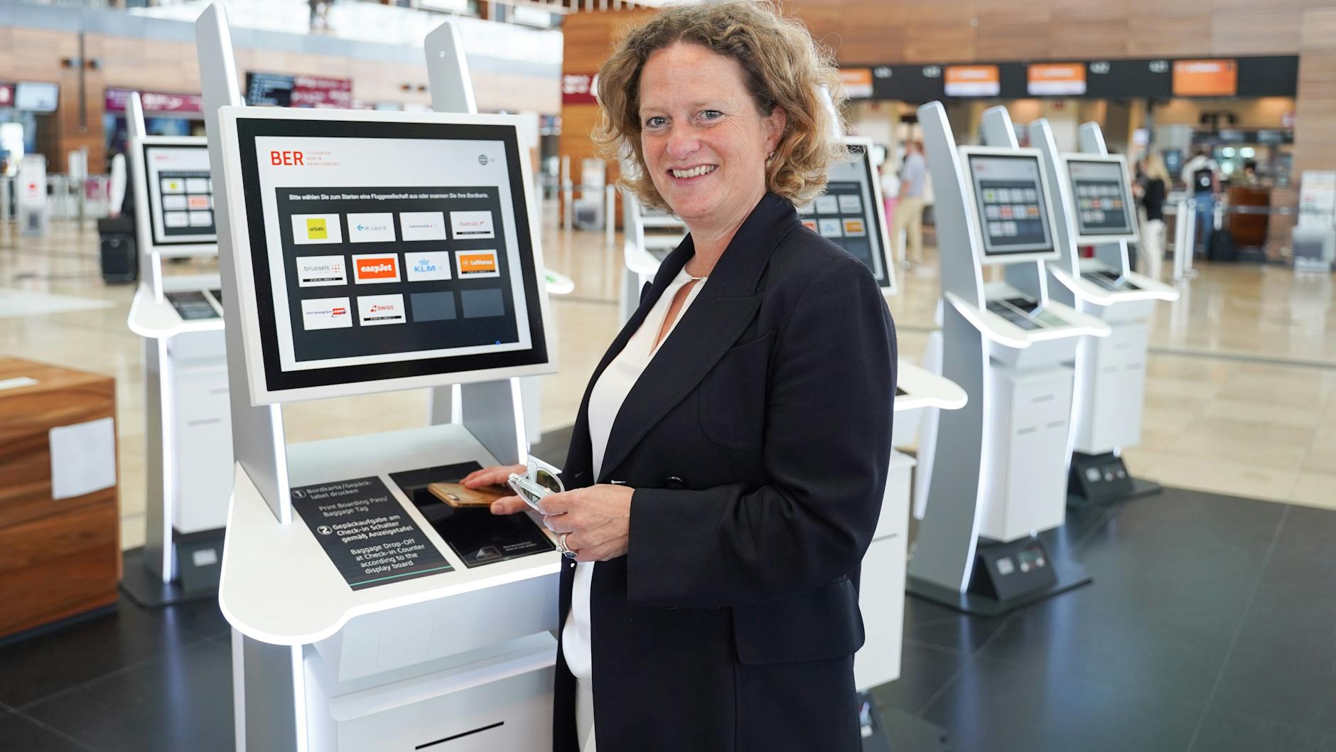 Zum Check-in-Schalter? Nicht mehr nötig! An 118 Automaten im BER kann man Bordkarten ausdrucken oder Gepäck aufgeben. Flughafenchefin Aletta von Massenbach testet ein Gerät in Terminal 1 des BER.