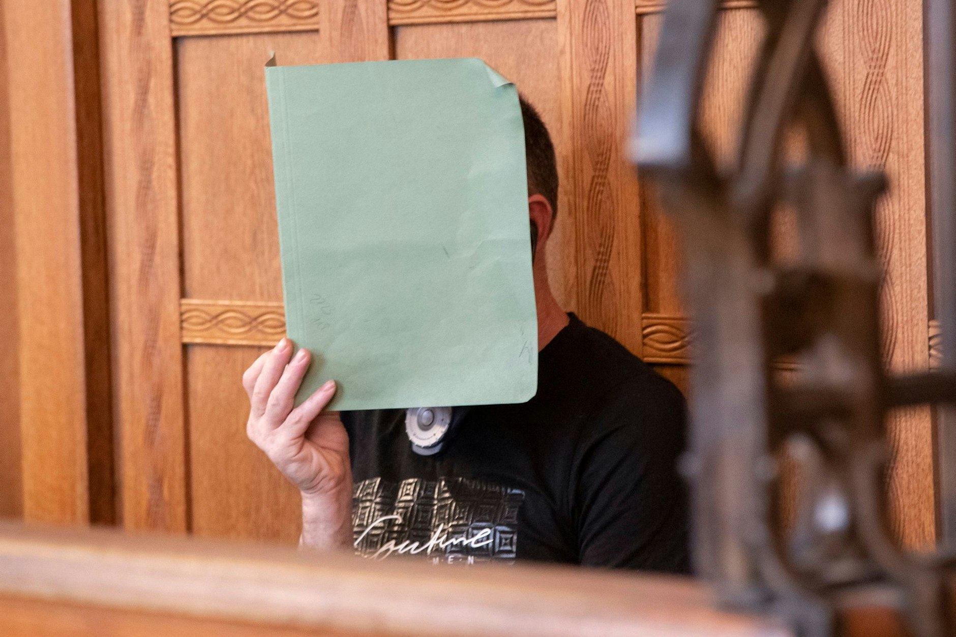 Ion P. versteckt im Gerichtssaal sein Gesicht hinter einer Akte.