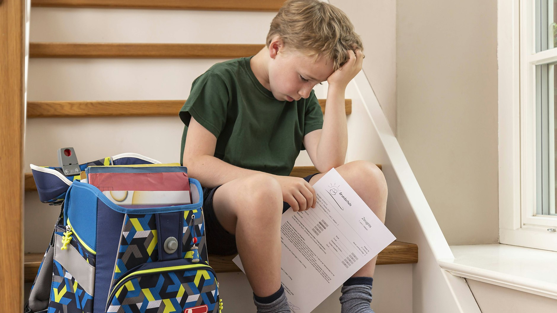 Enttäuschter Junge nach der Zeugnisübergabe (Symbolbild)