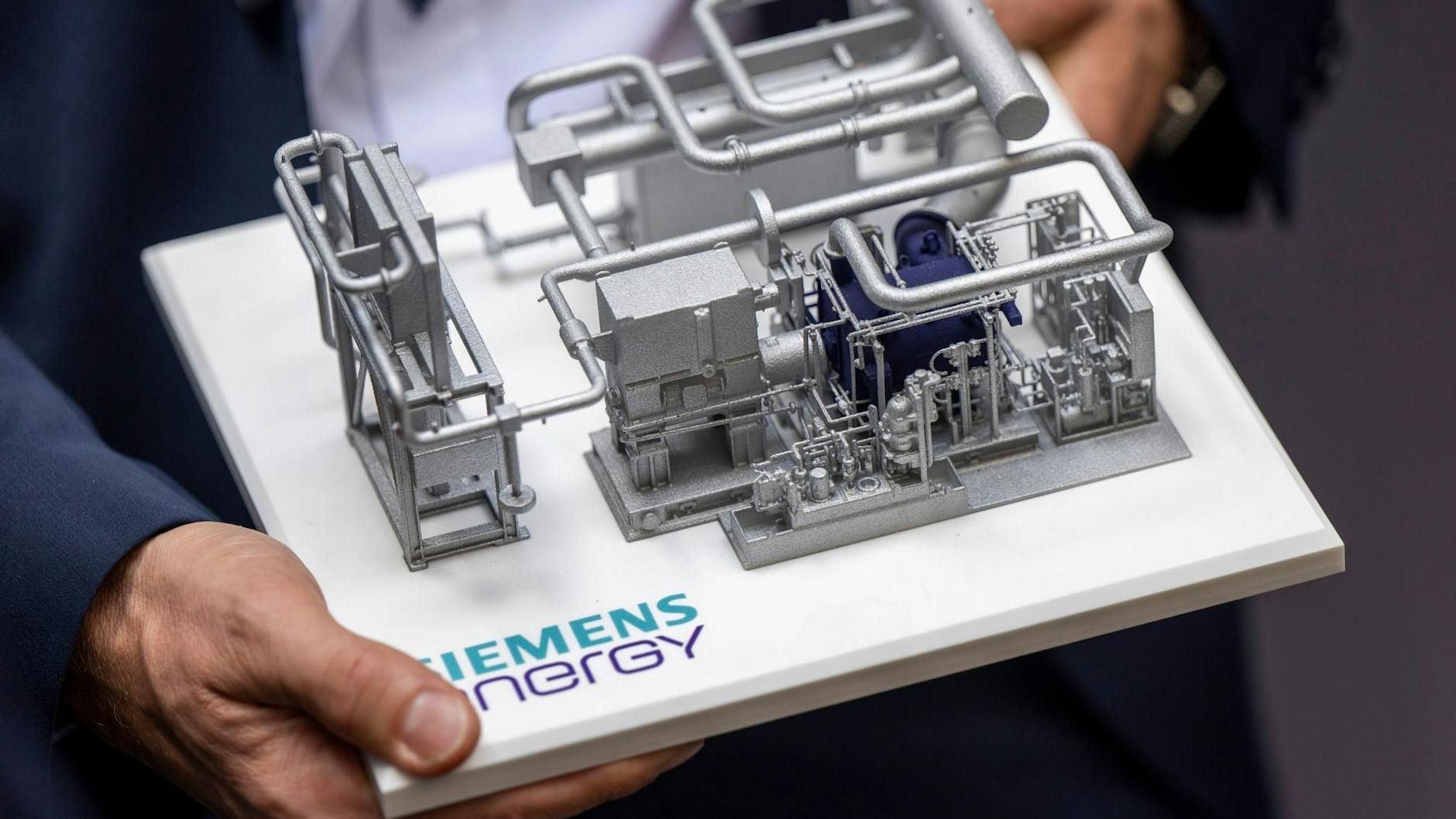 Ein Mitarbeiter der Firma Siemens Energy hält für die Hochtemperatur-Wärmepumpe in der Vattenfall-Kältezentrale das Modell der Pumpe in den Händen.