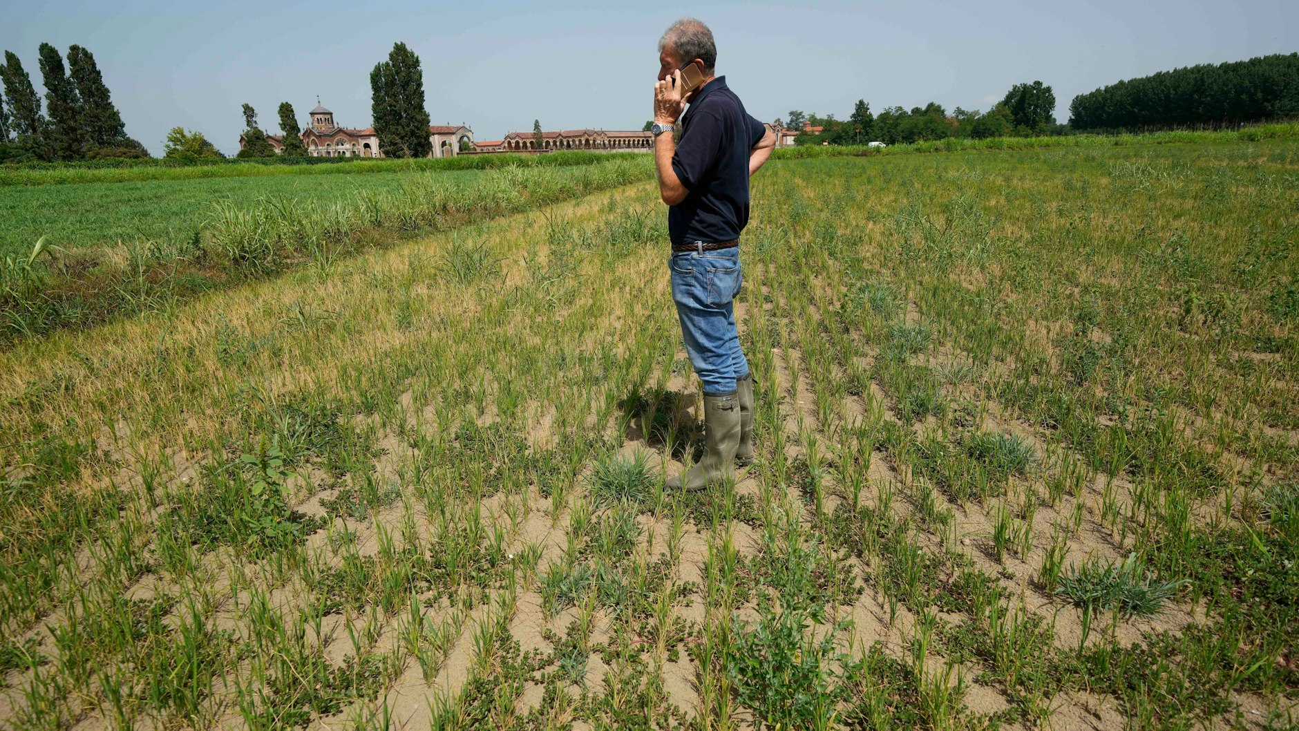 Reisbauer Giovanni Daghetta steht auf einem vertrockneten Reisfeld, das eigentlich unter Wasser stehen müsste. Die Gummistiefel hätte er sich sparen können.