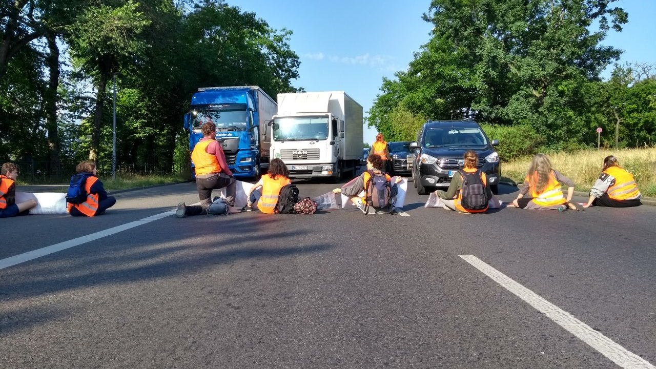 Aktivistinnen haben sich auf der Fahrbahn festgeklebt.