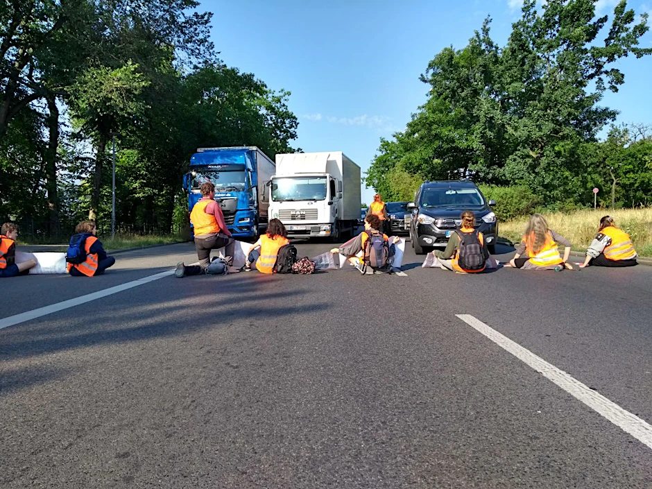 Aktivistinnen haben sich auf der Fahrbahn festgeklebt.