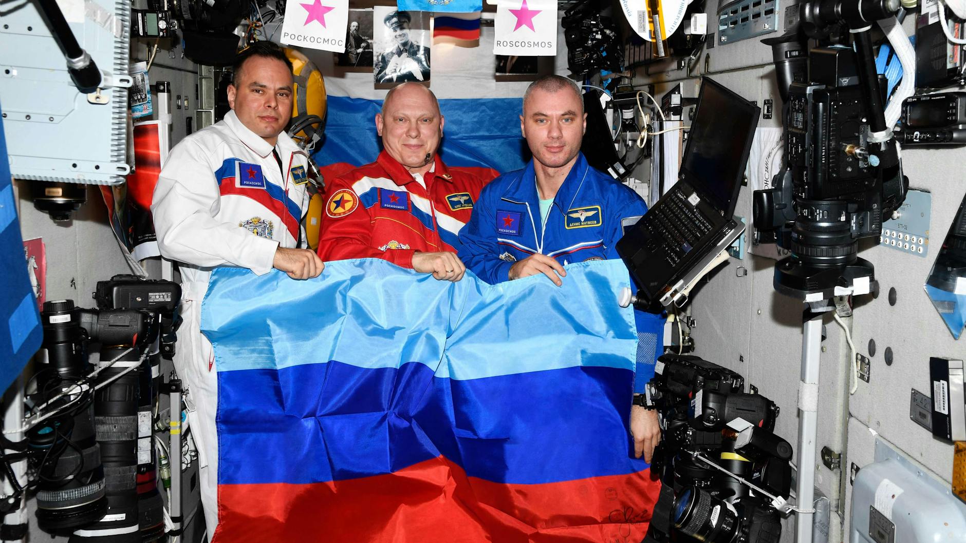 Die Kosmonauten Oleg Artemjew, Denis Matwejew und Sergej Korssakow posieren mit der Flagge der „Volksrepubliken“ Luhansk und Donezk.
