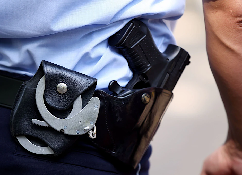 Ein&nbsp;Polizist trägt Handschellen und seine Dienstwaffe bei sich.
