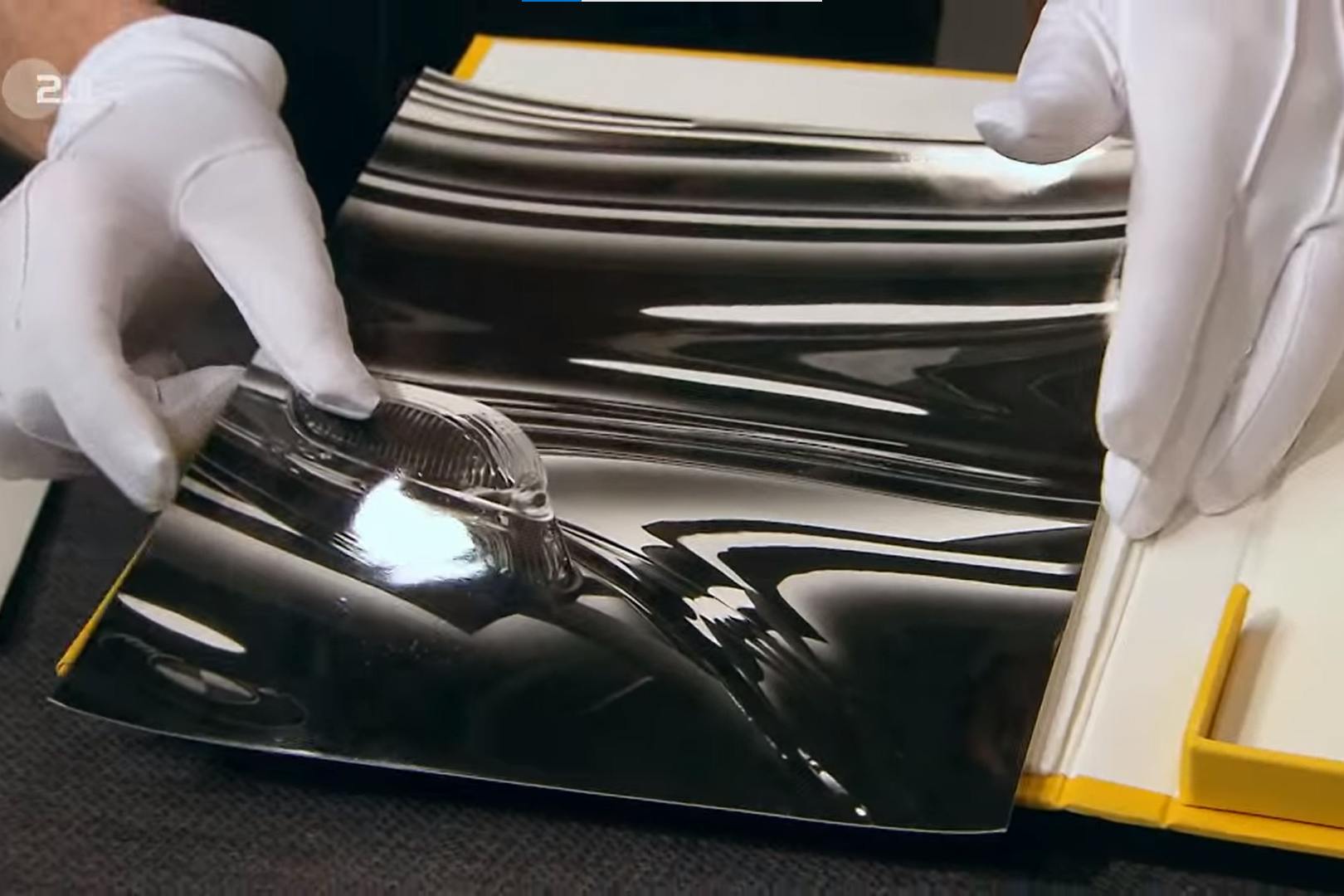 Colmar muss das Foto vorsichtig mit Handschuhen berühren, um es nicht zu beschädigen.