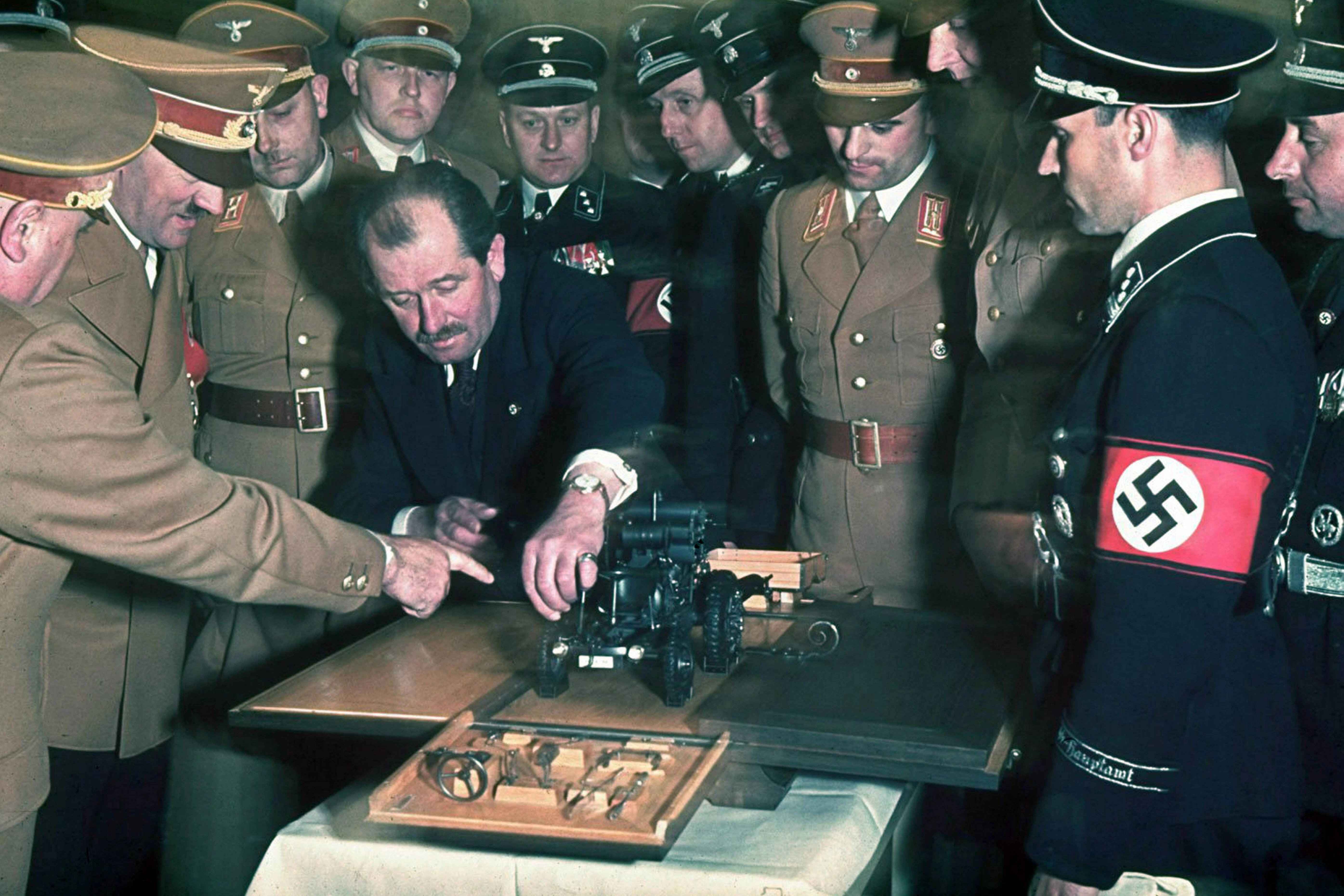Automobilingenieur und Konstrukteur Ferdinand Porsche (1875–1951) überreicht Adolf Hitler ein Modellauto während der Feierlichkeiten zu dessen 50. Geburtstag. Fotografiert von Hugo Jaeger. Datiert 1939.