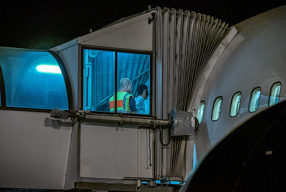 Ein Beamter schiebt eine Person durch den Eingang eines Flugzeuges. (Symbolbild)