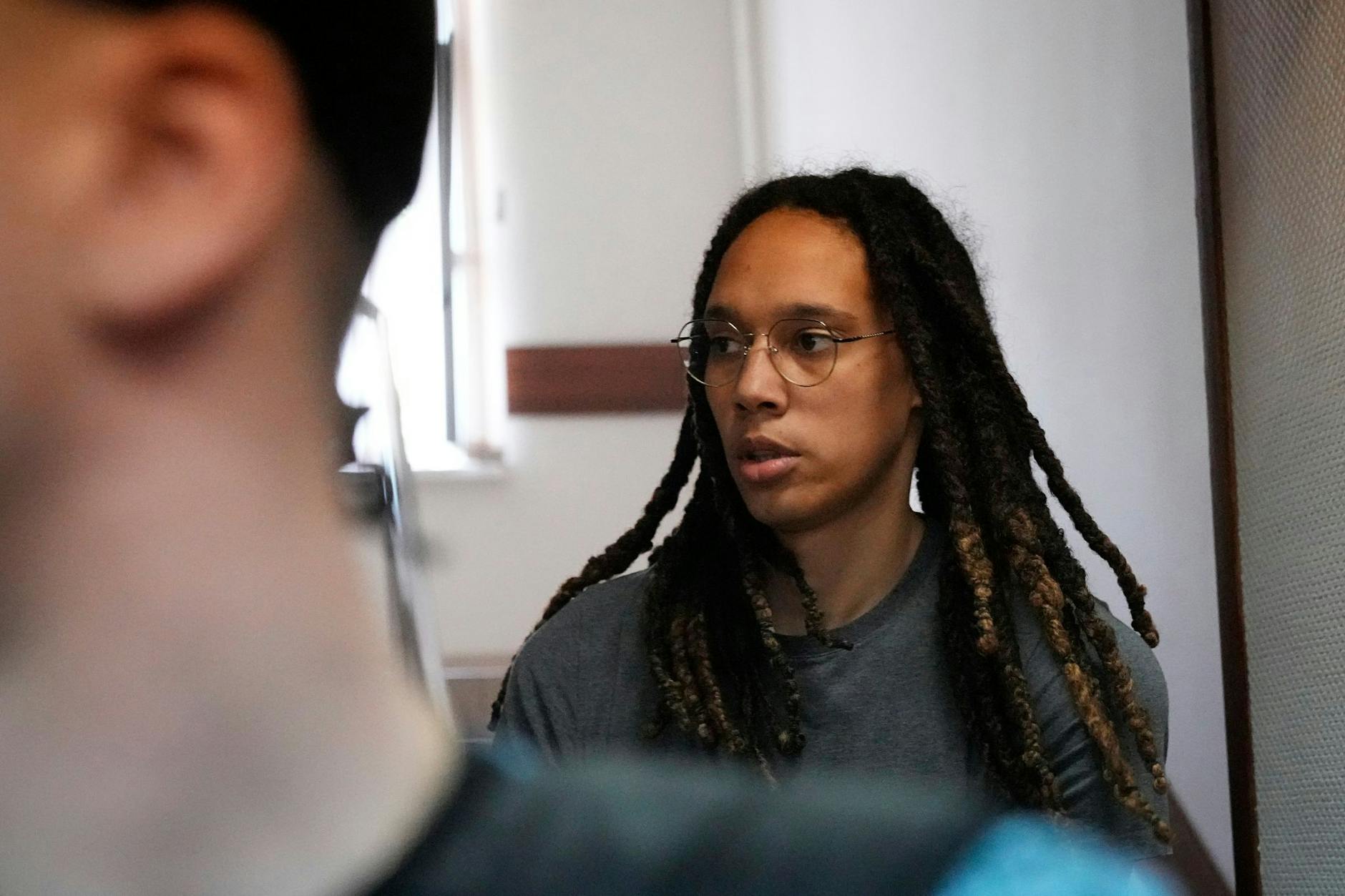 Brittney Griner wird in Russland zu einer Anhörung in einem Gerichtssaal gebracht.